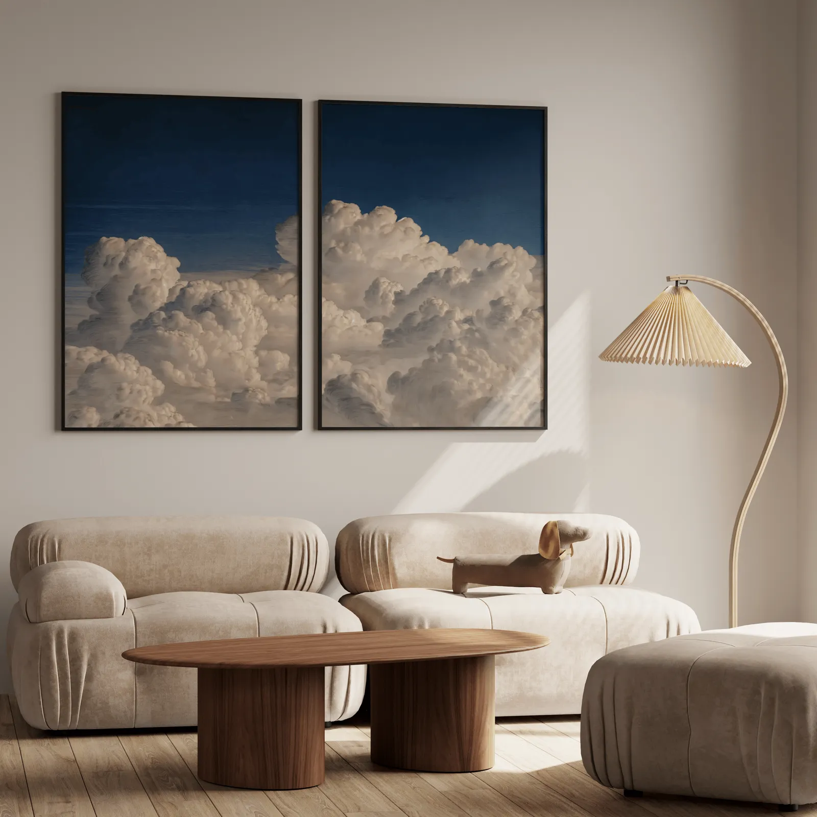 blue sky cloud landscape wall art set of two, above a plush beige sofa with a pleated lamp nearby