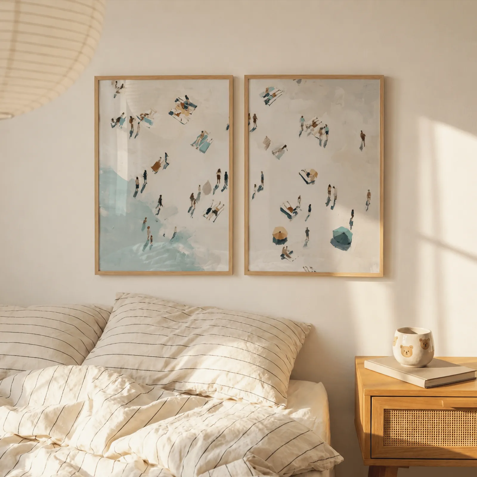 beach wall art set of 2 aerial coastal scene, above a striped linen bed beside a paper lantern shade