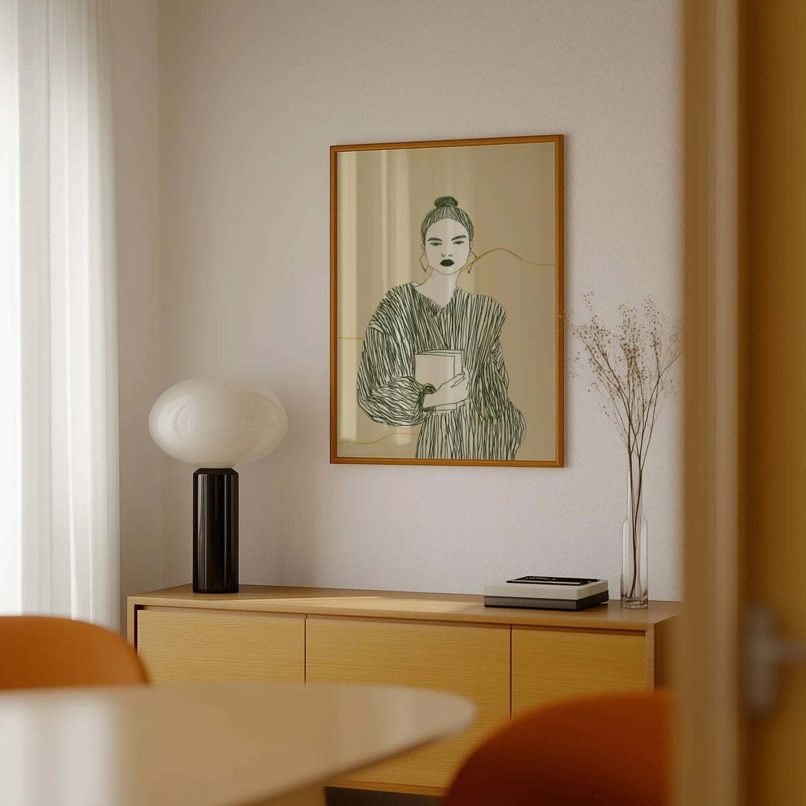 beige green modern woman reading wall art, above a light wood sideboard beside a bulbous black lamp