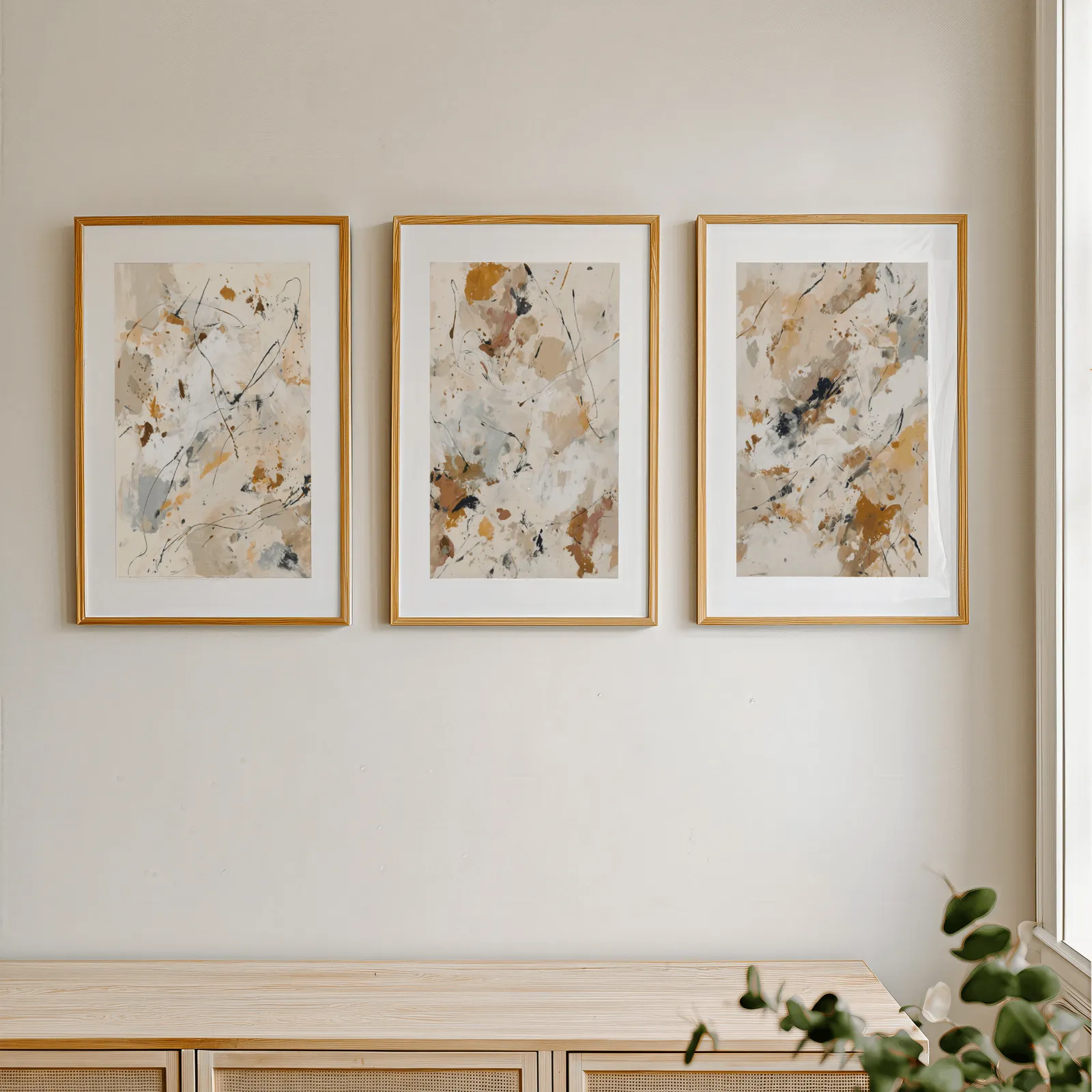 abstract neutral wall art set of 3 in terracotta and grey, in a row above a light wooden sideboard near a window