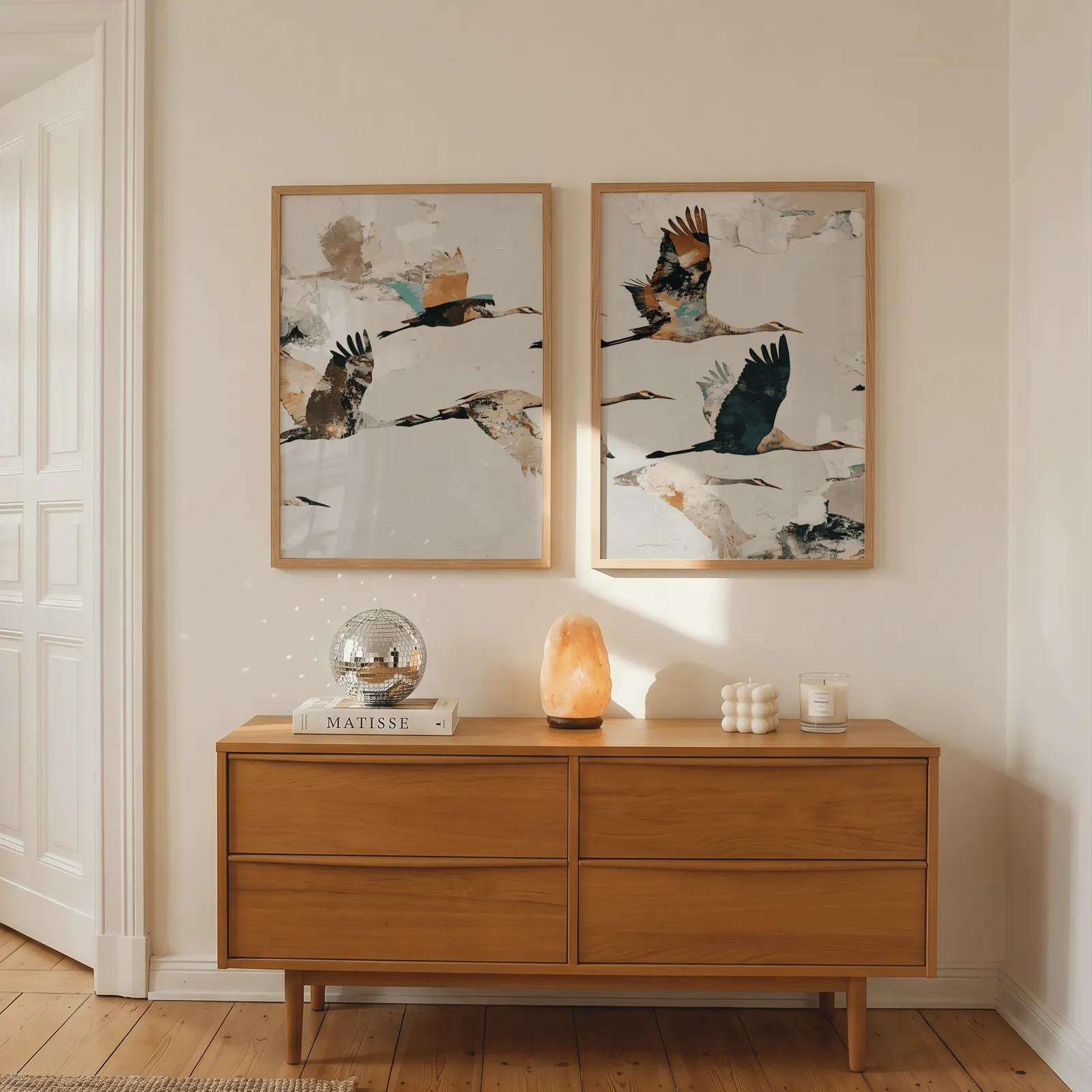 terracotta crane wall art set of two, above a wooden dresser with a salt lamp and disco ball