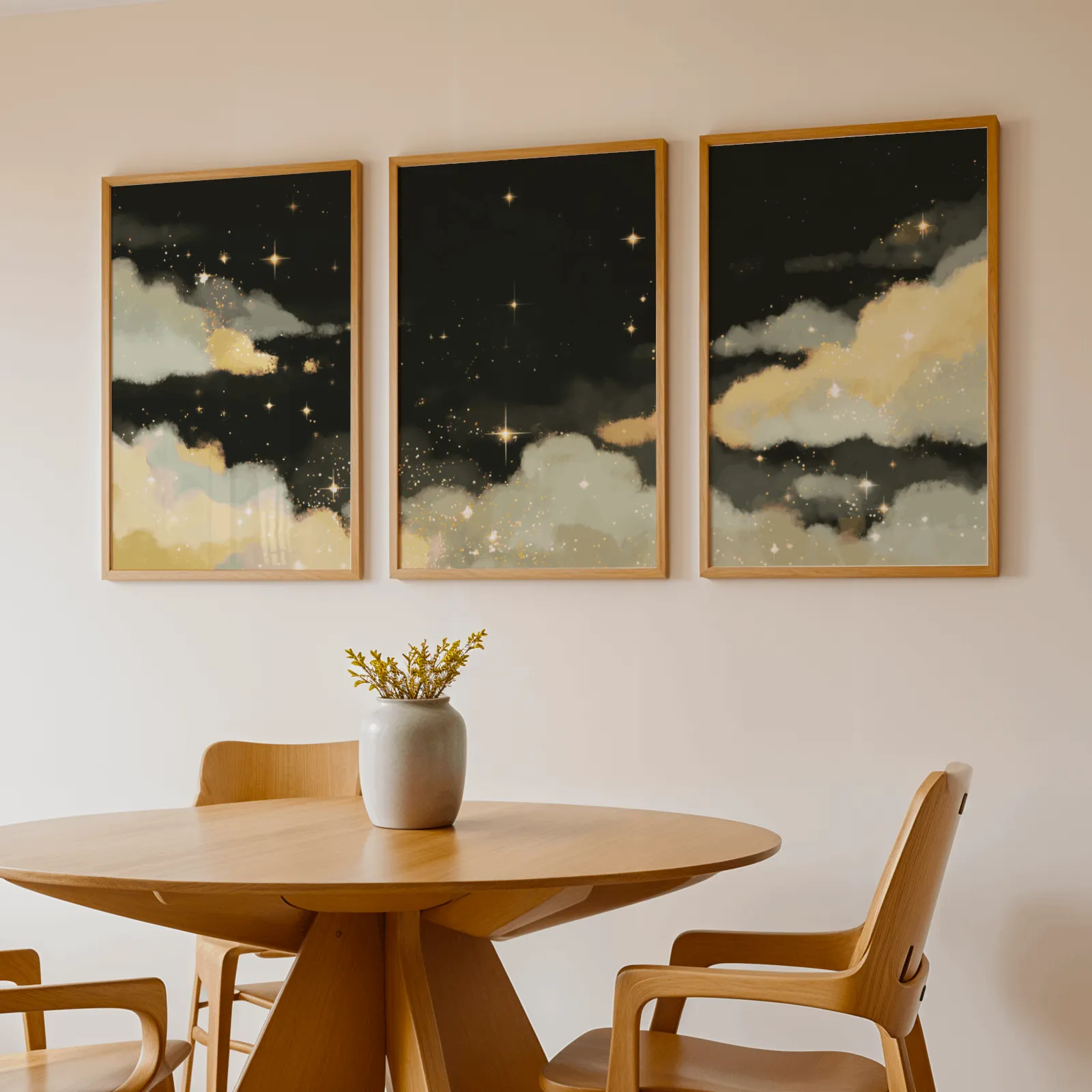 black and gold starry sky triptych wall art, above a round wooden table with a stoneware vase
