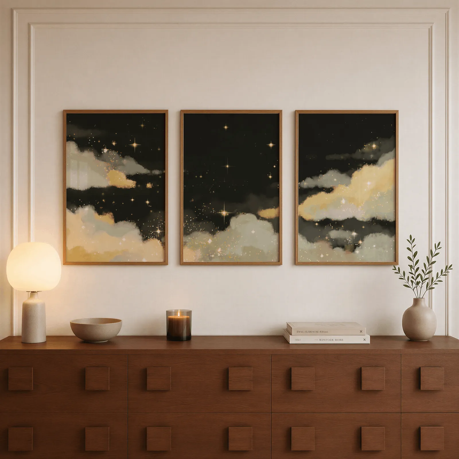black and gold starry sky triptych wall art, above a walnut sideboard with a lit candle and glowing lamp