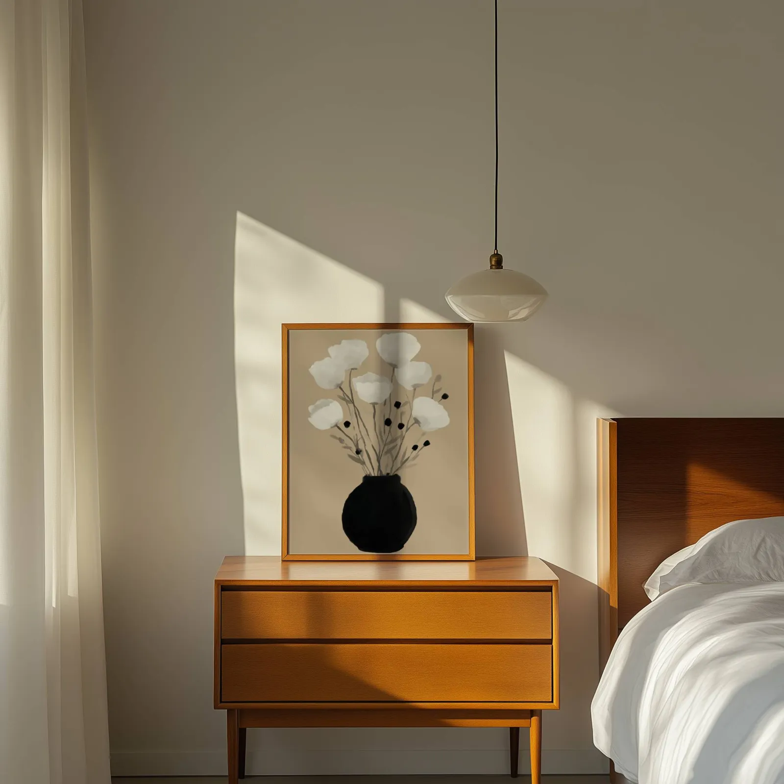 minimalist botanical wall art with black vase and white flowers, propped on a wooden dresser beside a pendant lamp