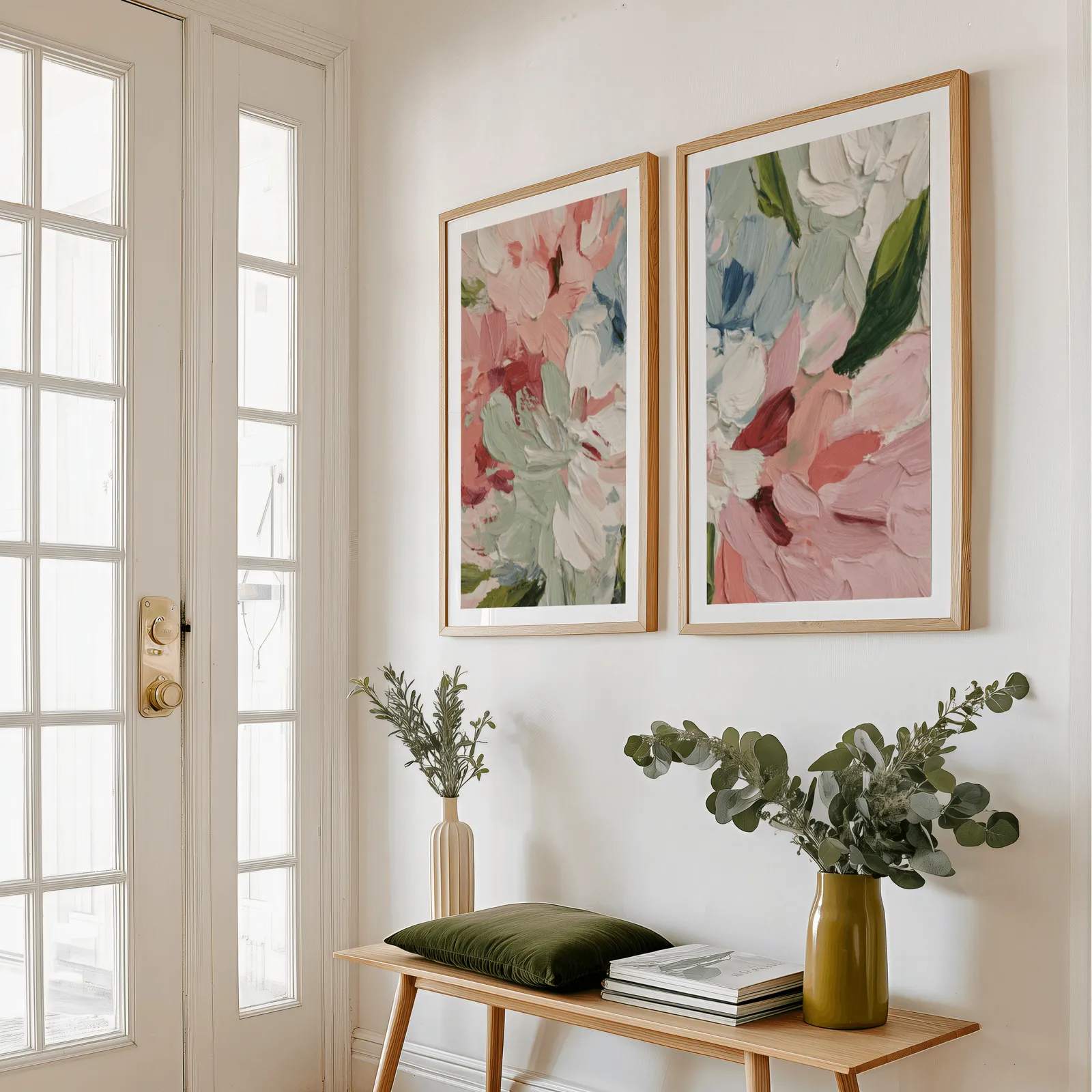 pink abstract floral wall art set of two, above a wooden bench with eucalyptus stems and a green cushion