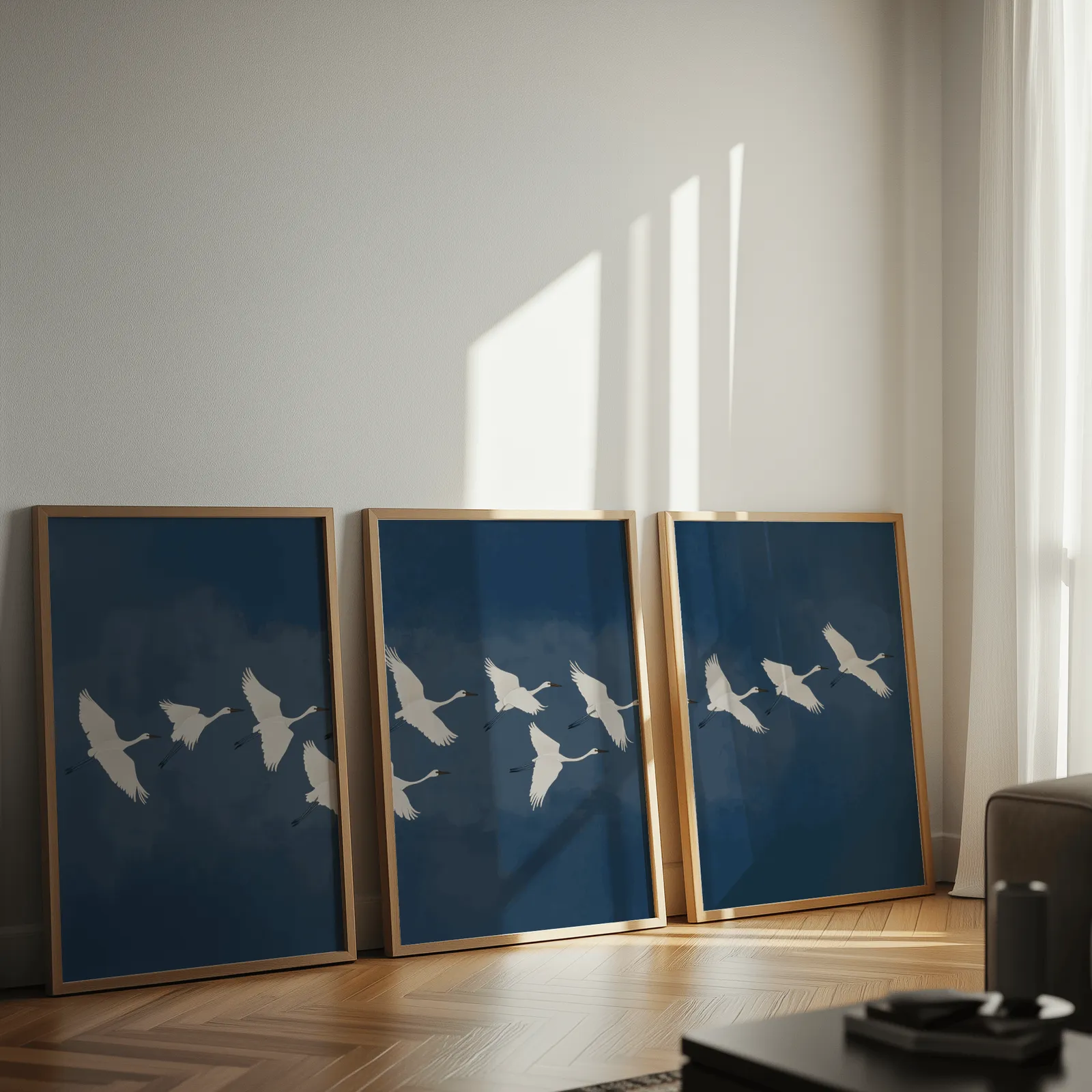 blue crane triptych wall art set, leaning against a sunlit wall on herringbone flooring