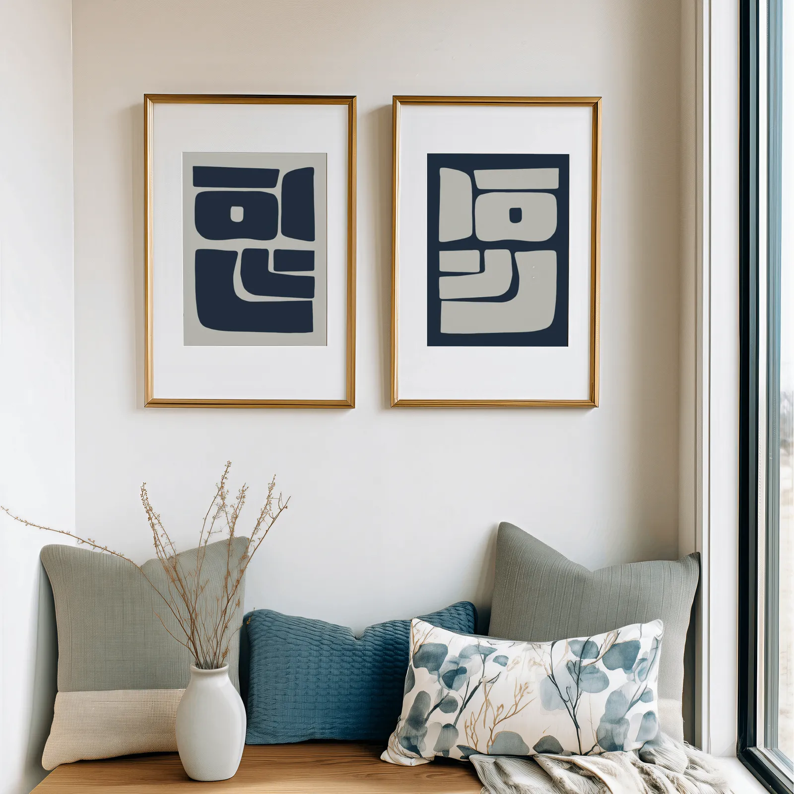 blue and grey abstract minimalist wall art set of two, above a cushioned window seat with sage and blue pillows
