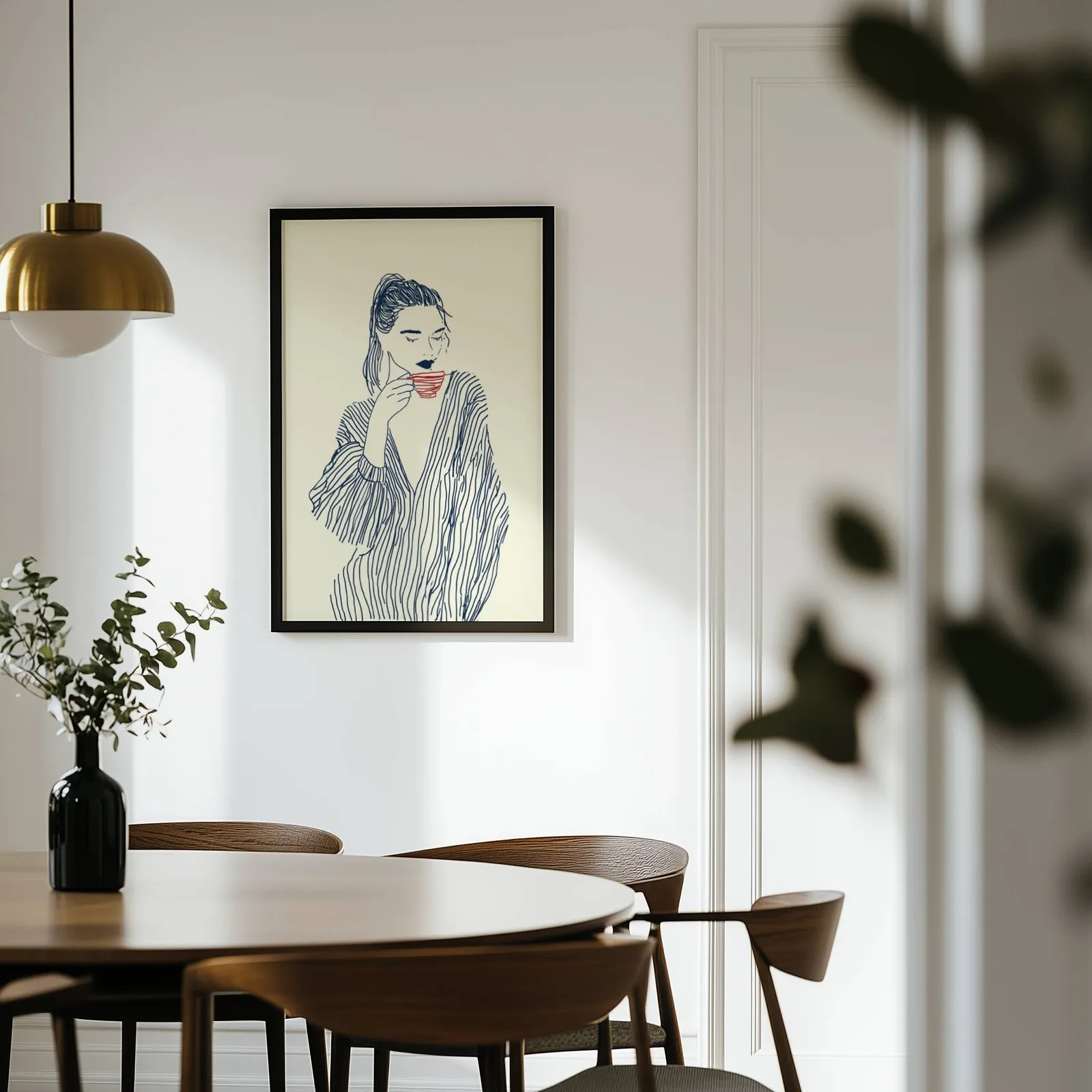 minimalist line art woman drinking coffee wall art, on a white wall above a round wooden dining table
