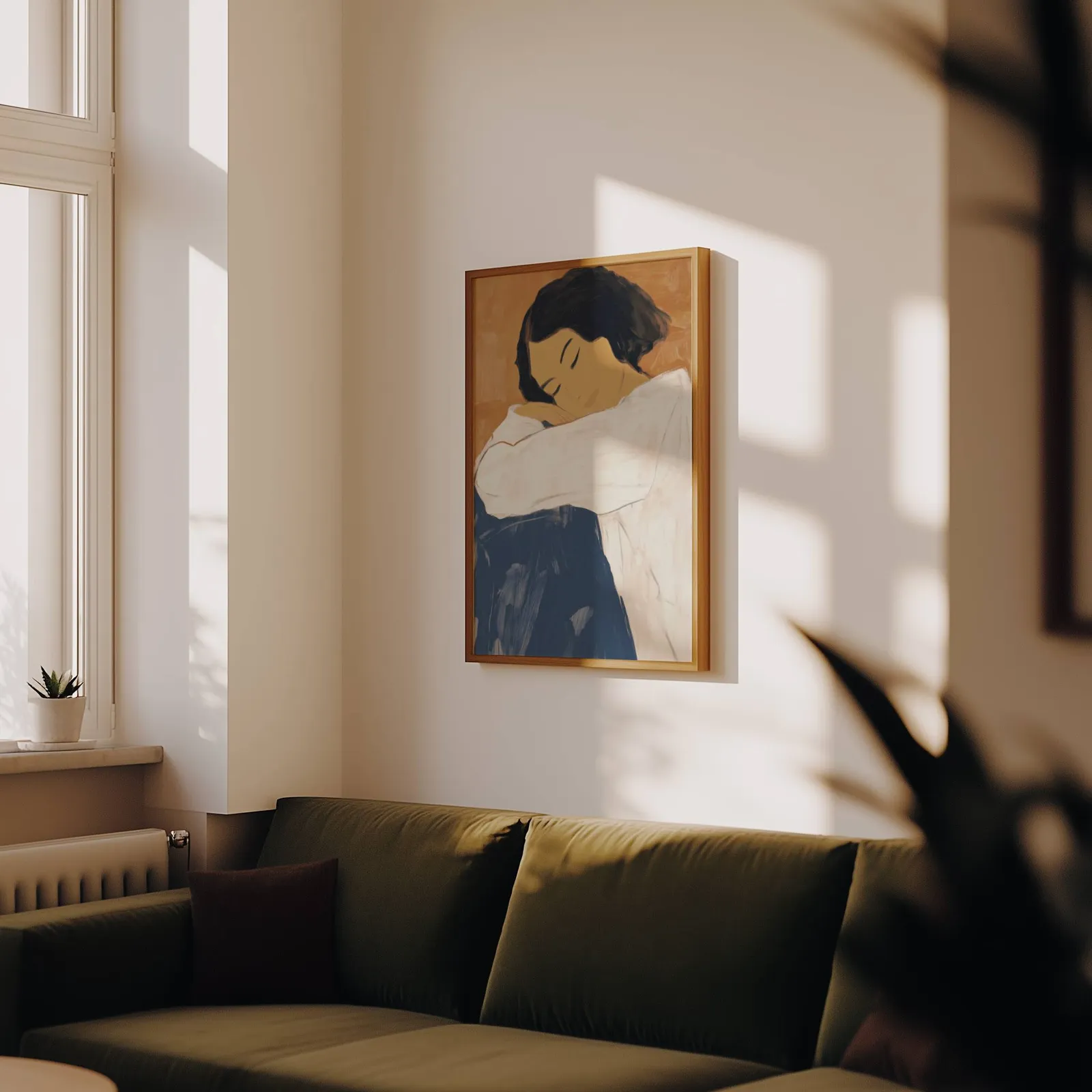 abstract woman wall art in blue and terracotta, above an olive velvet sofa in raking afternoon light