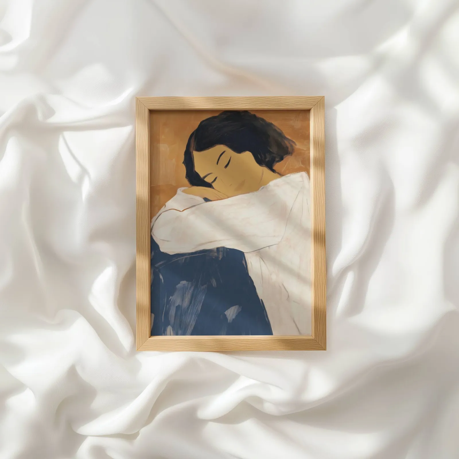 abstract woman wall art in blue and terracotta, resting atop rumpled white silky fabric