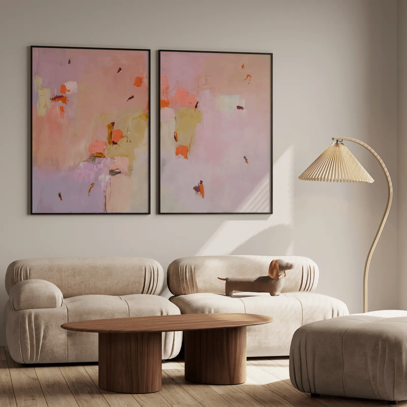 pink abstract wall art set of two, above a plush beige sofa with a pleated lamp nearby