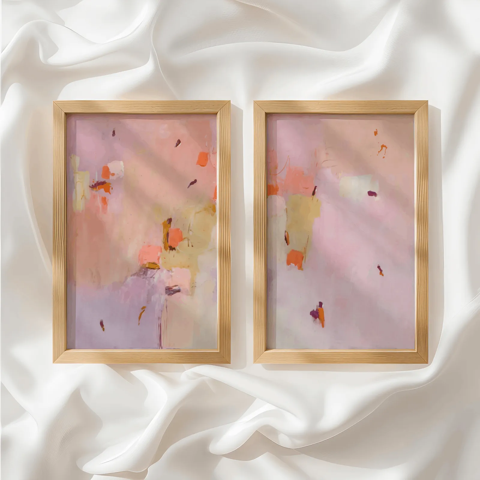 pink abstract wall art set of two, side by side atop rumpled white silky fabric