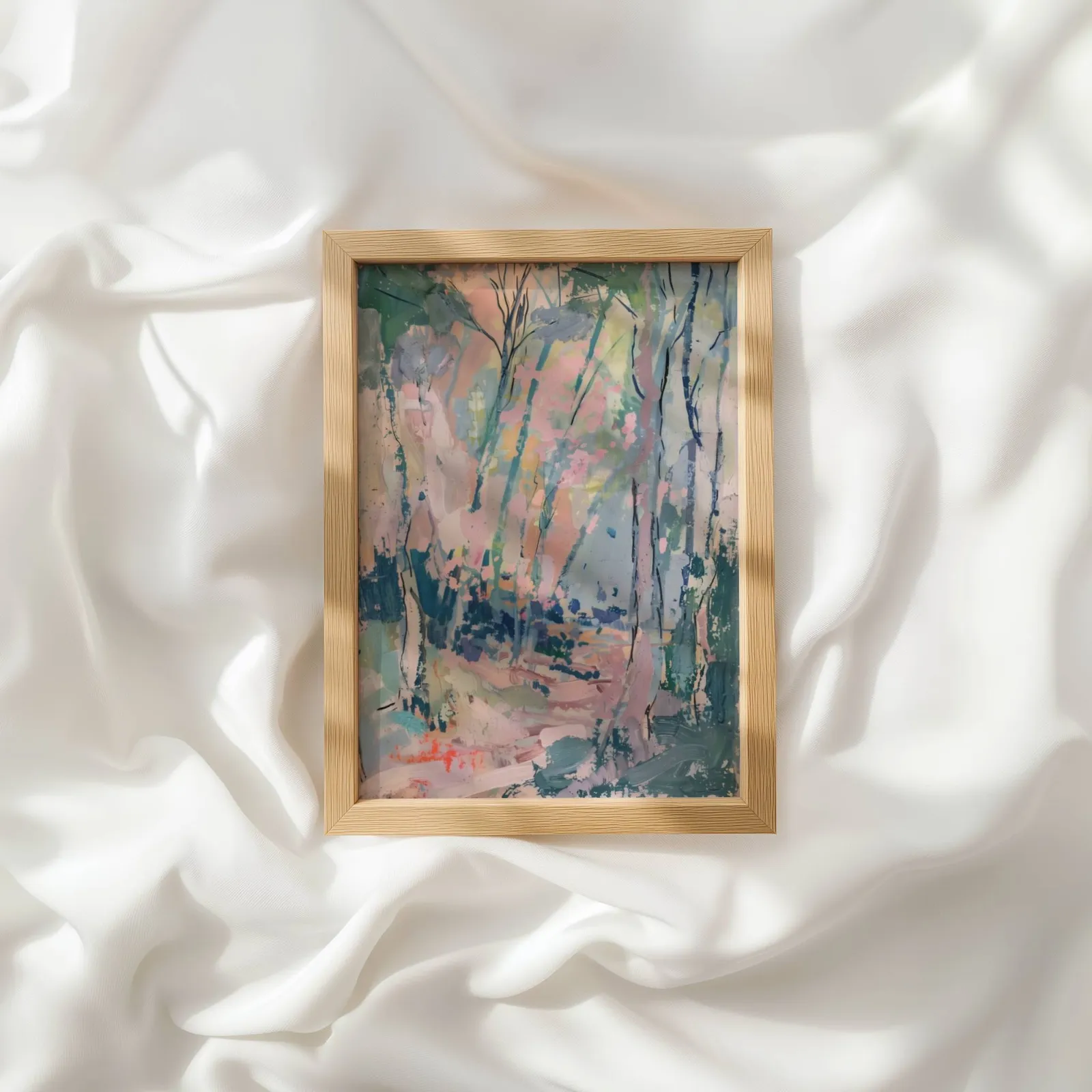 pink and green abstract forest wall art, resting atop rumpled white silky fabric
