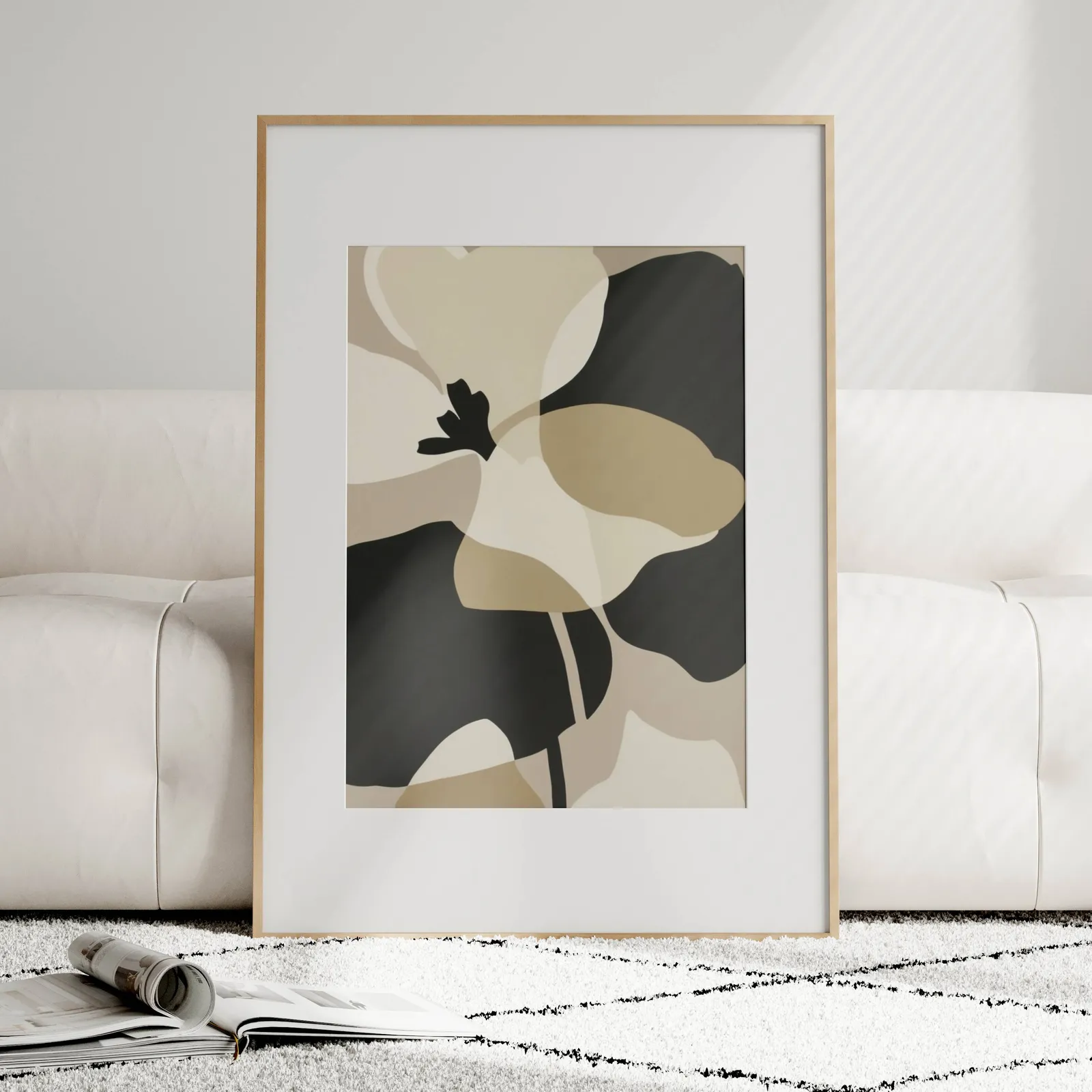 black and beige abstract botanical wall art, leaning against a plush cream sofa on a patterned rug