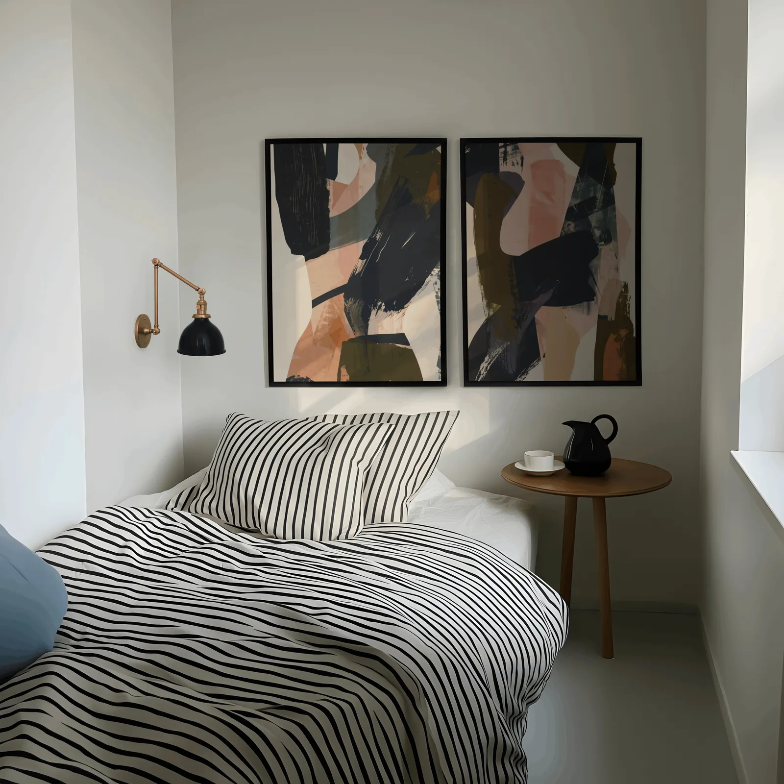 blue terracotta abstract wall art set of 2, above a striped bed beside a brass swing-arm lamp