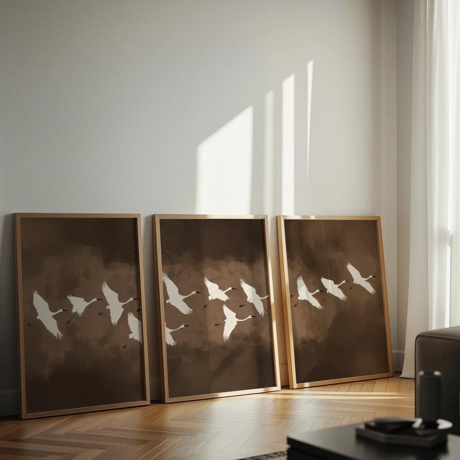 brown minimalist crane wall art set of three, leaning against a sunlit wall on herringbone flooring