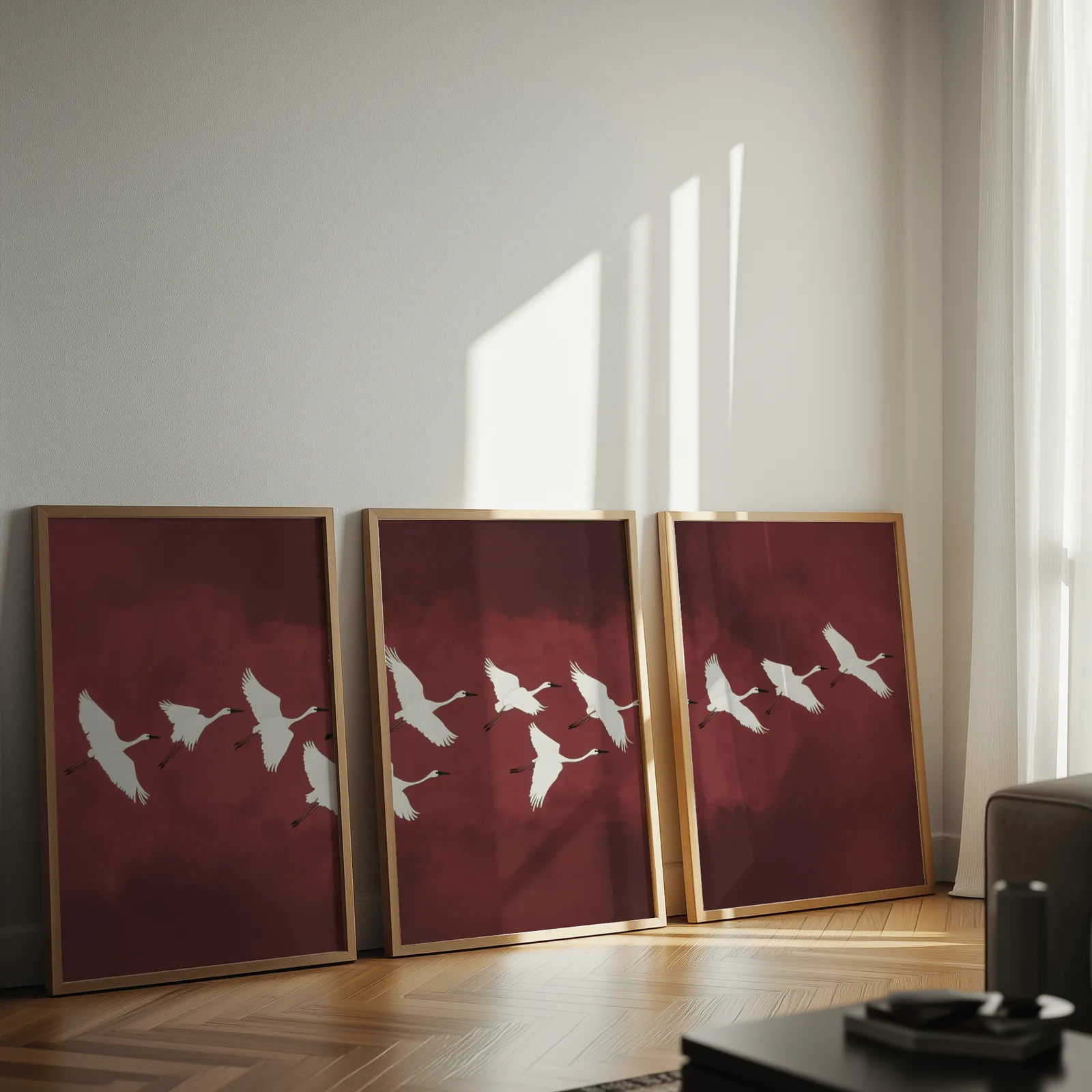 burgundy crane flight triptych wall art, leaning against a sunlit wall on herringbone flooring