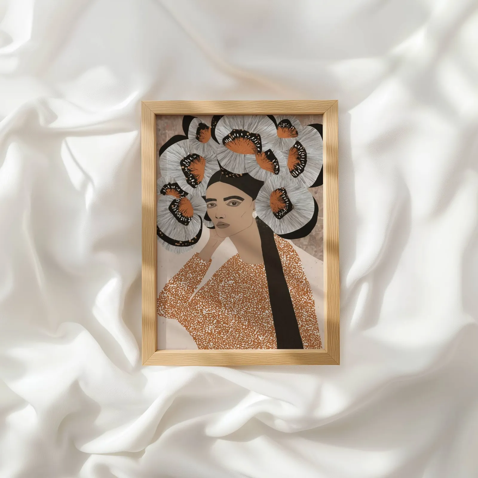 terracotta portrait wall art with butterfly crown, resting atop rumpled white silky fabric