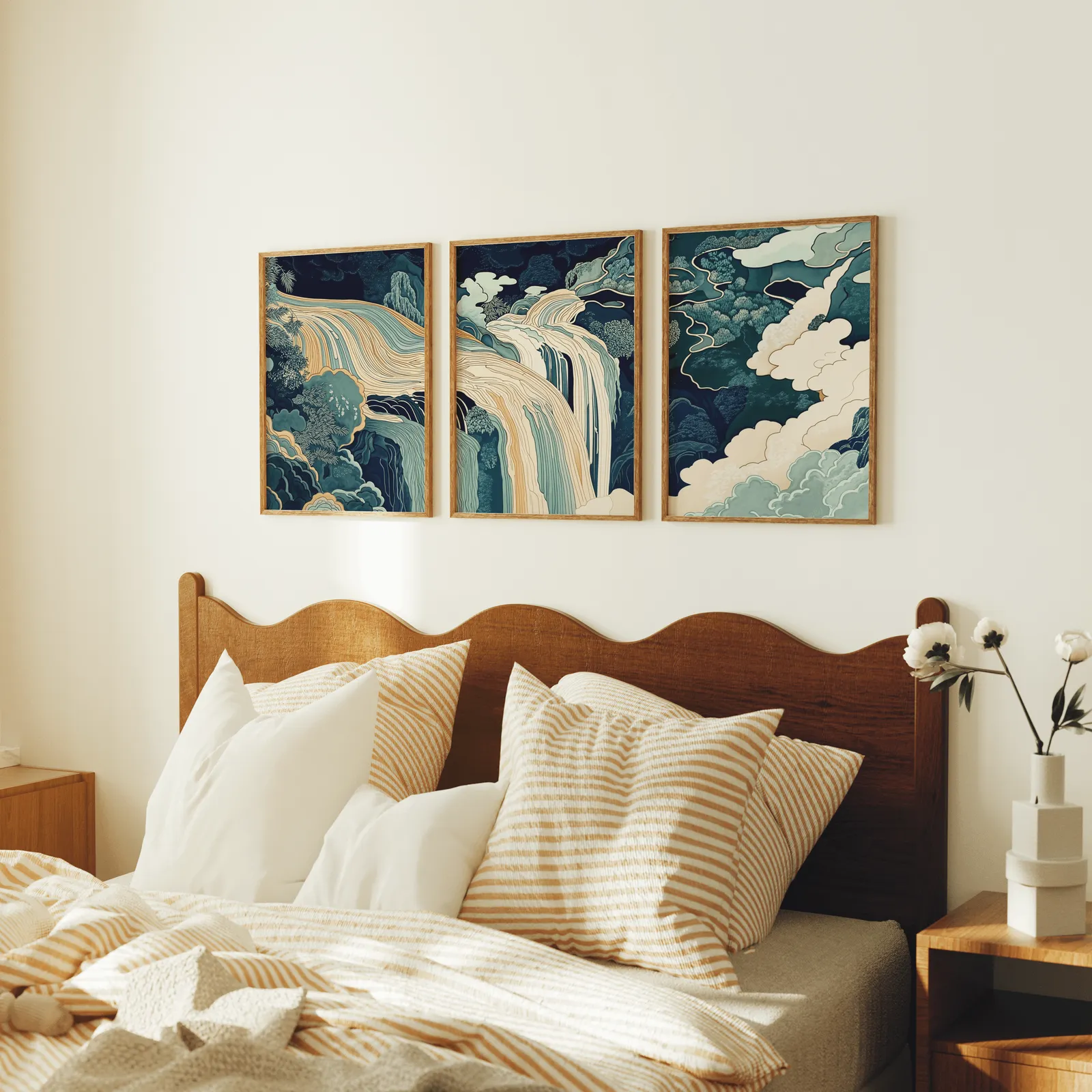 blue green waterfall landscape triptych wall art, above a scalloped wooden headboard with striped pillows