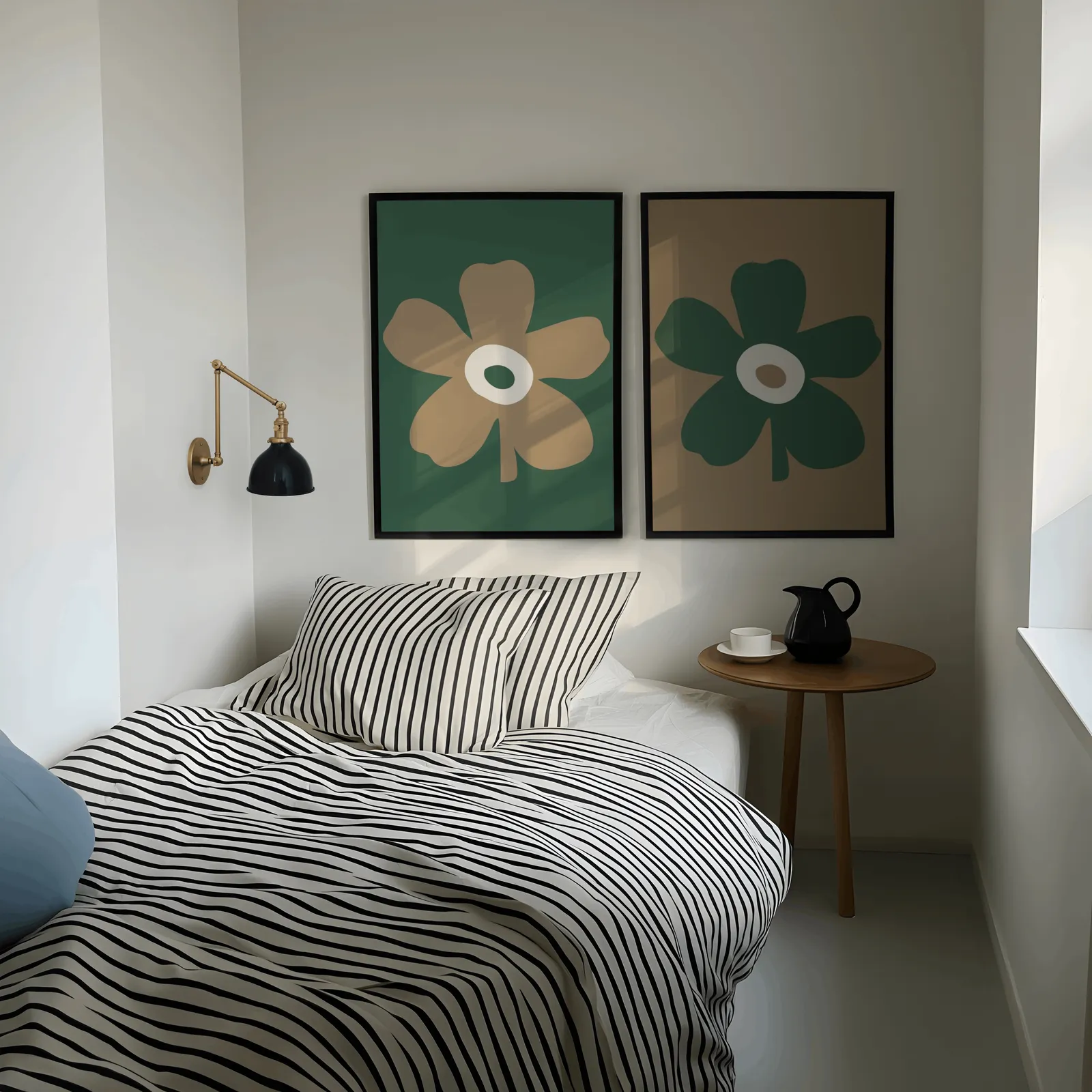 green and brown botanical flower wall art set of two, above a striped bed beside a brass swing-arm lamp