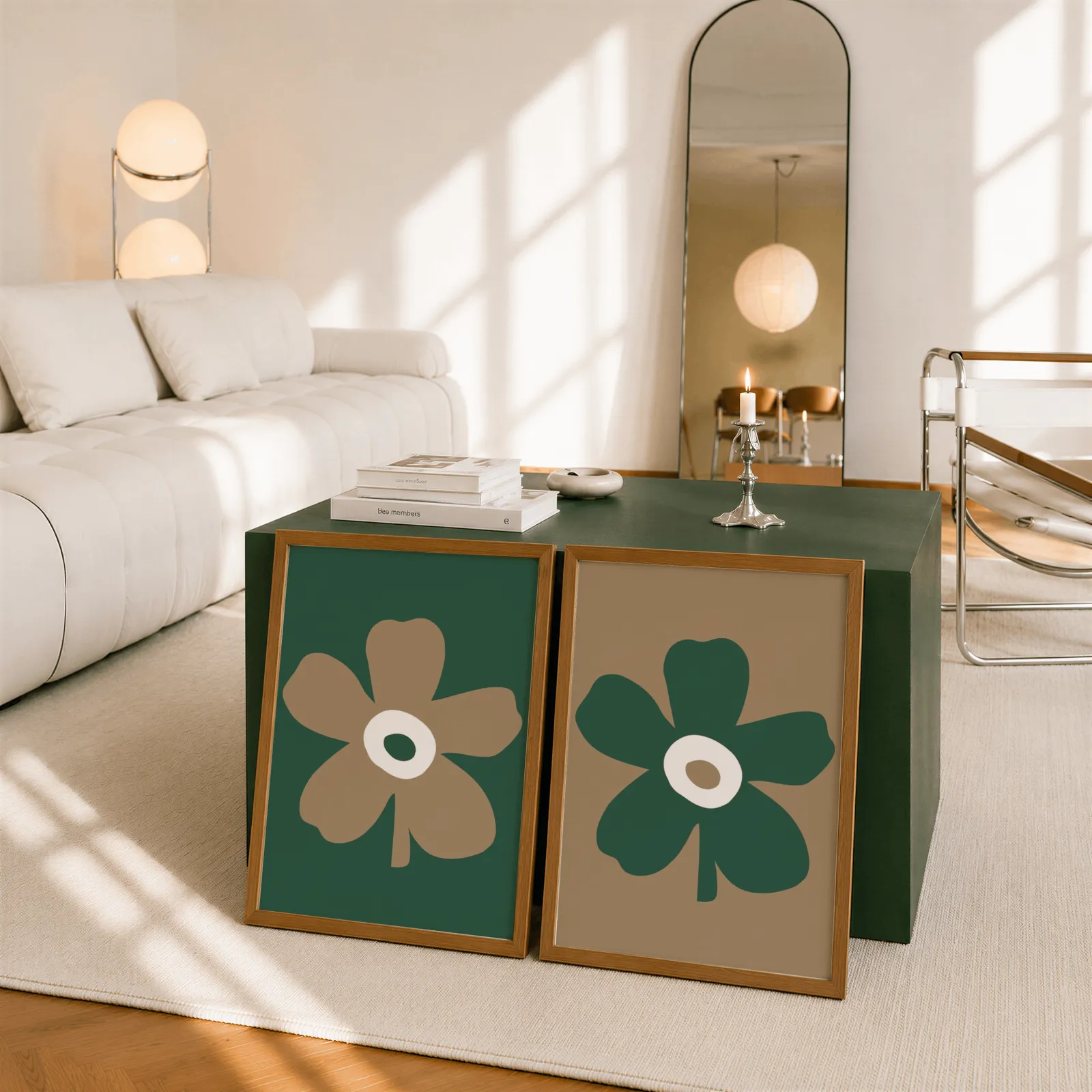 green and brown botanical flower wall art set of two, leaning against a dark green cube table beside an arched mirror