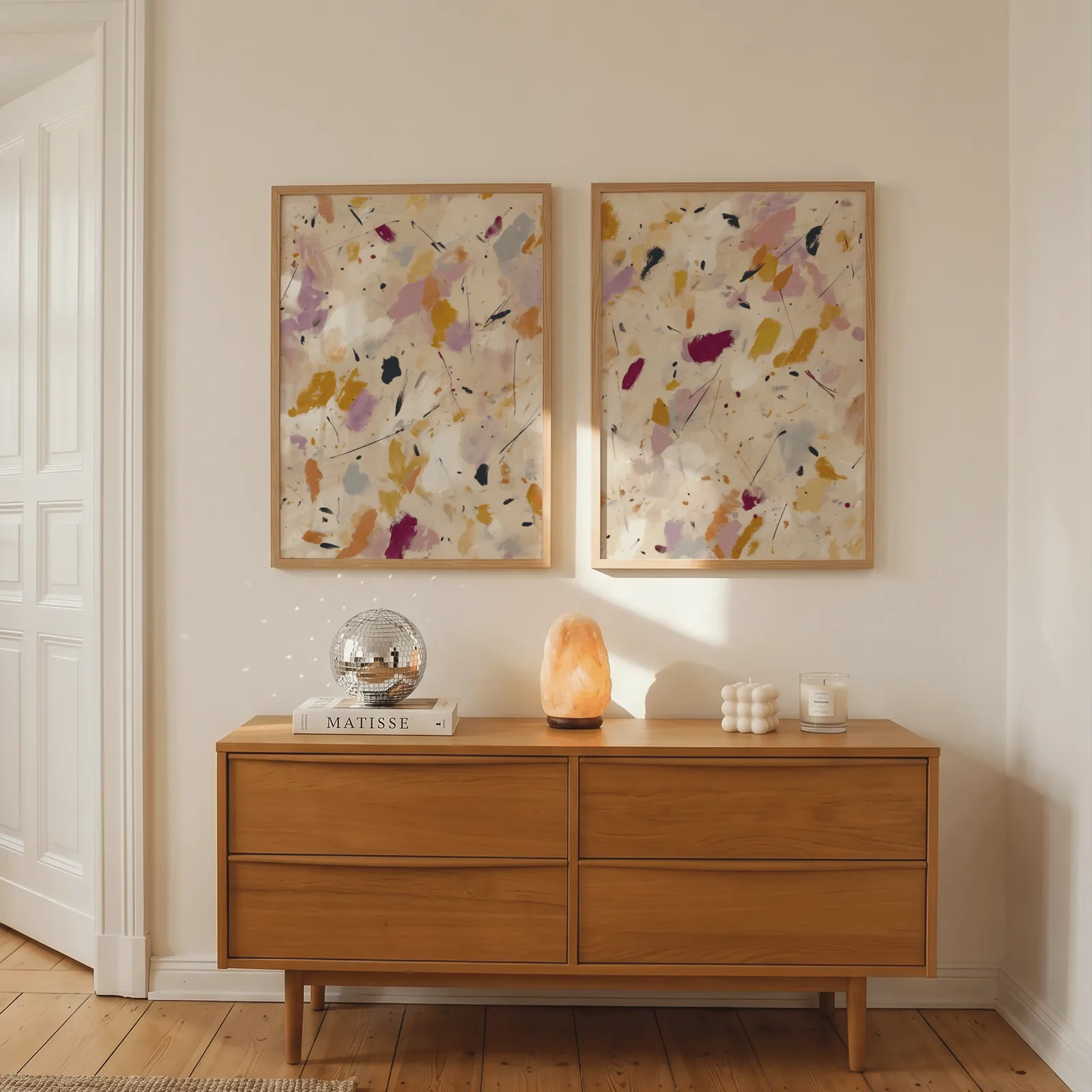 colorful abstract confetti wall art set of two, above a wooden dresser with a salt lamp and disco ball