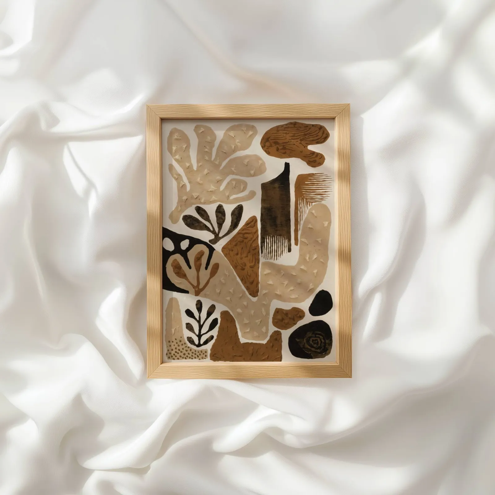 brown abstract botanical wall art, resting atop rumpled white silky fabric