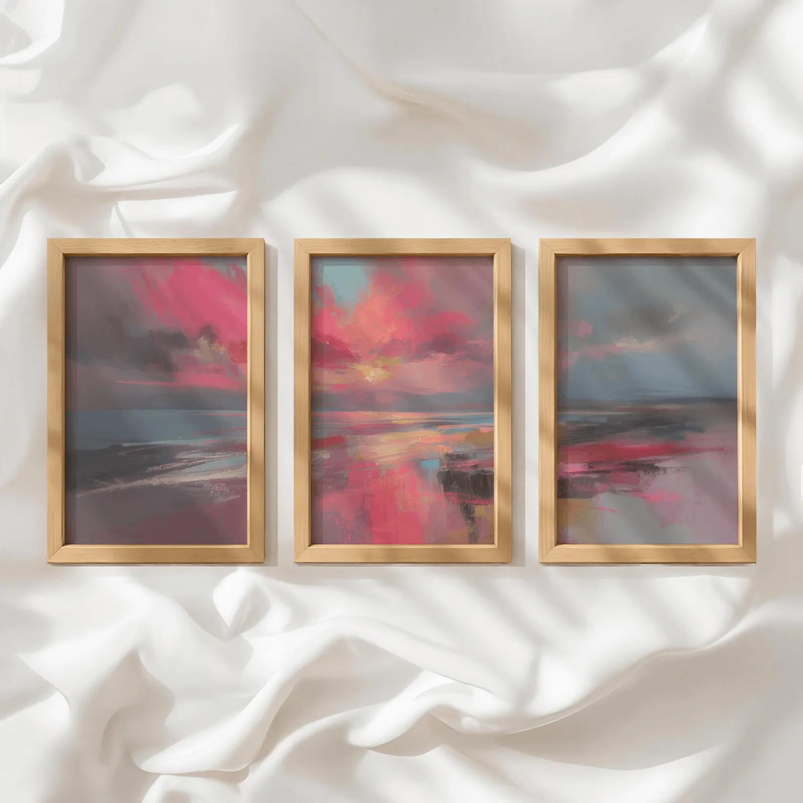 pink coastal sunset abstract triptych wall art, in a row atop rumpled white silky fabric
