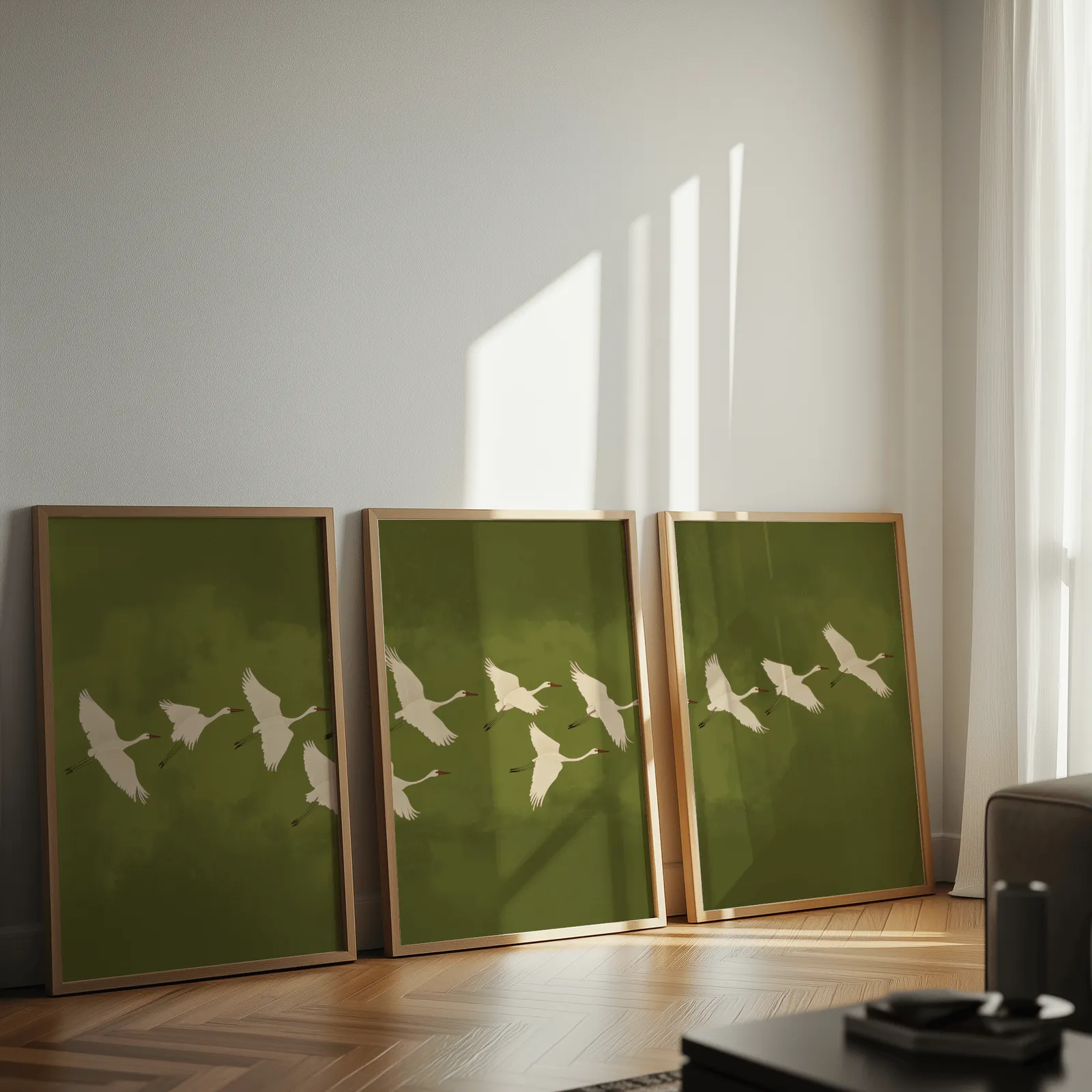 green crane wall art set of 3, leaning against a sunlit wall on herringbone flooring