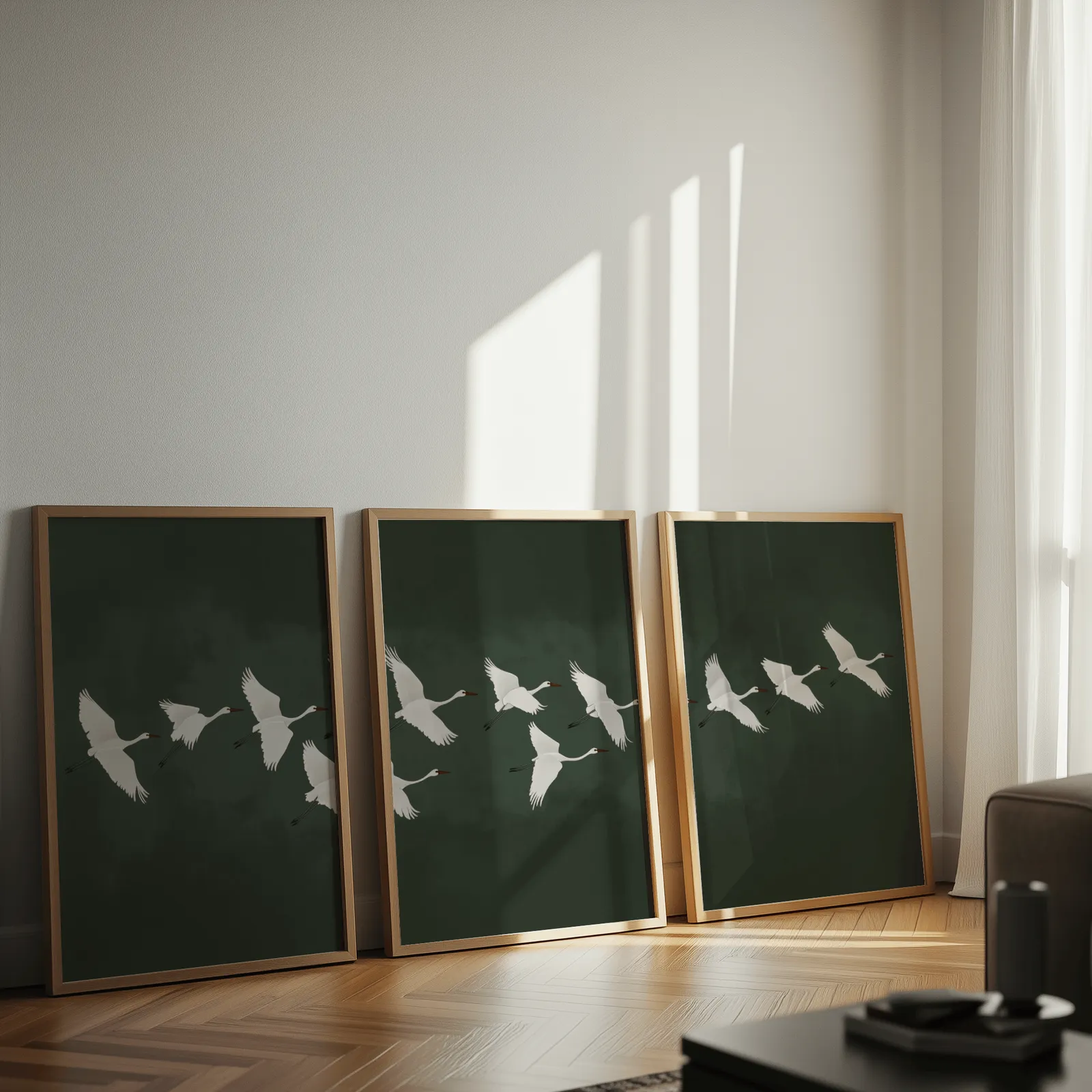 green crane wall art set of 3, leaning against a sunlit wall on herringbone flooring