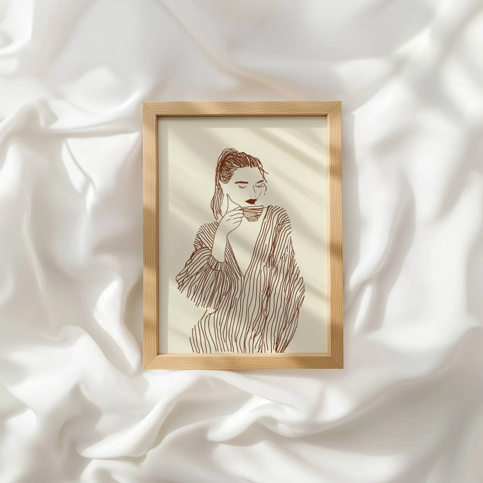 woman drinking coffee line art print, resting atop rumpled white silky fabric