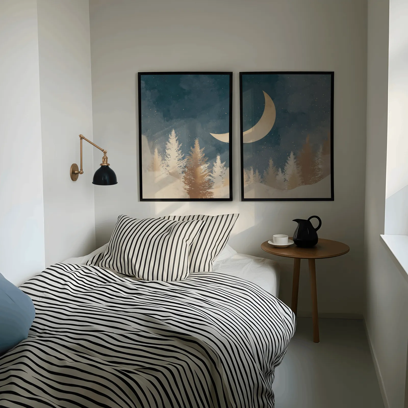 blue forest wall art set with crescent moon, above a striped bed beside a brass swing-arm lamp