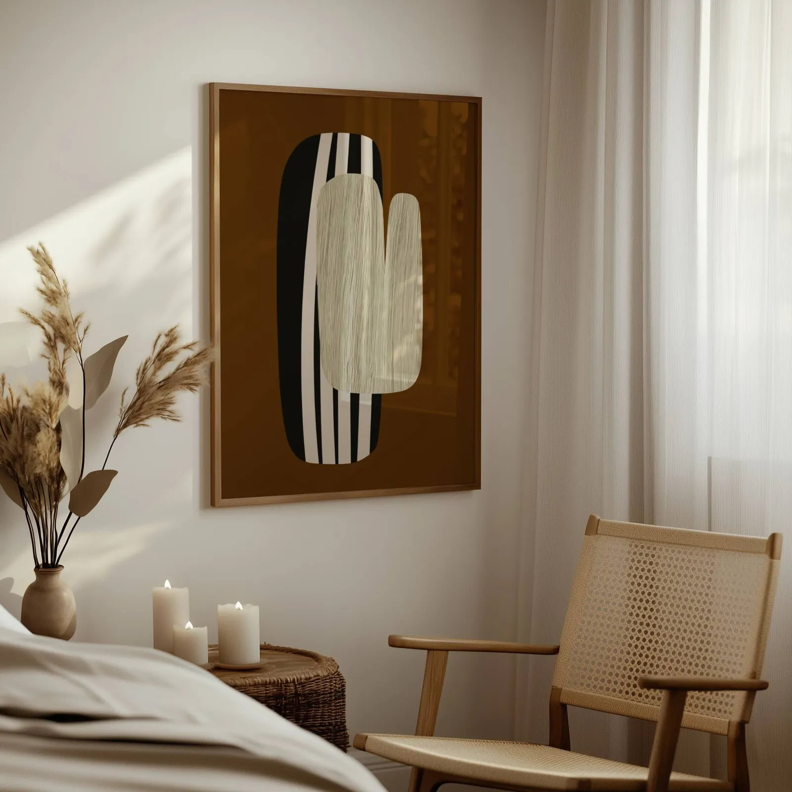 brown abstract wall art, above a woven side table with lit candles and pampas grass