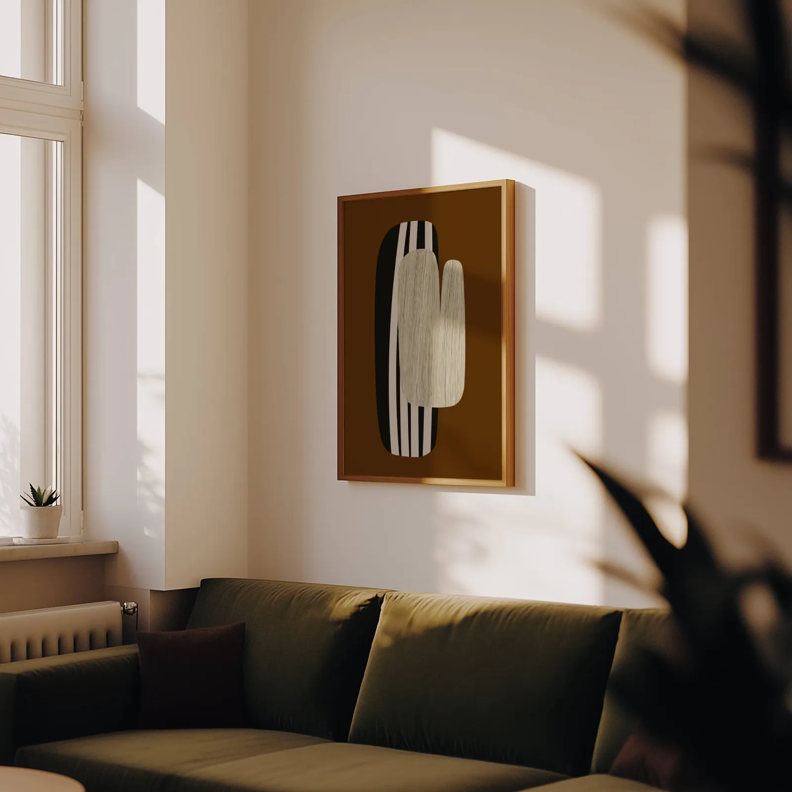 brown abstract wall art, above an olive velvet sofa in raking afternoon light