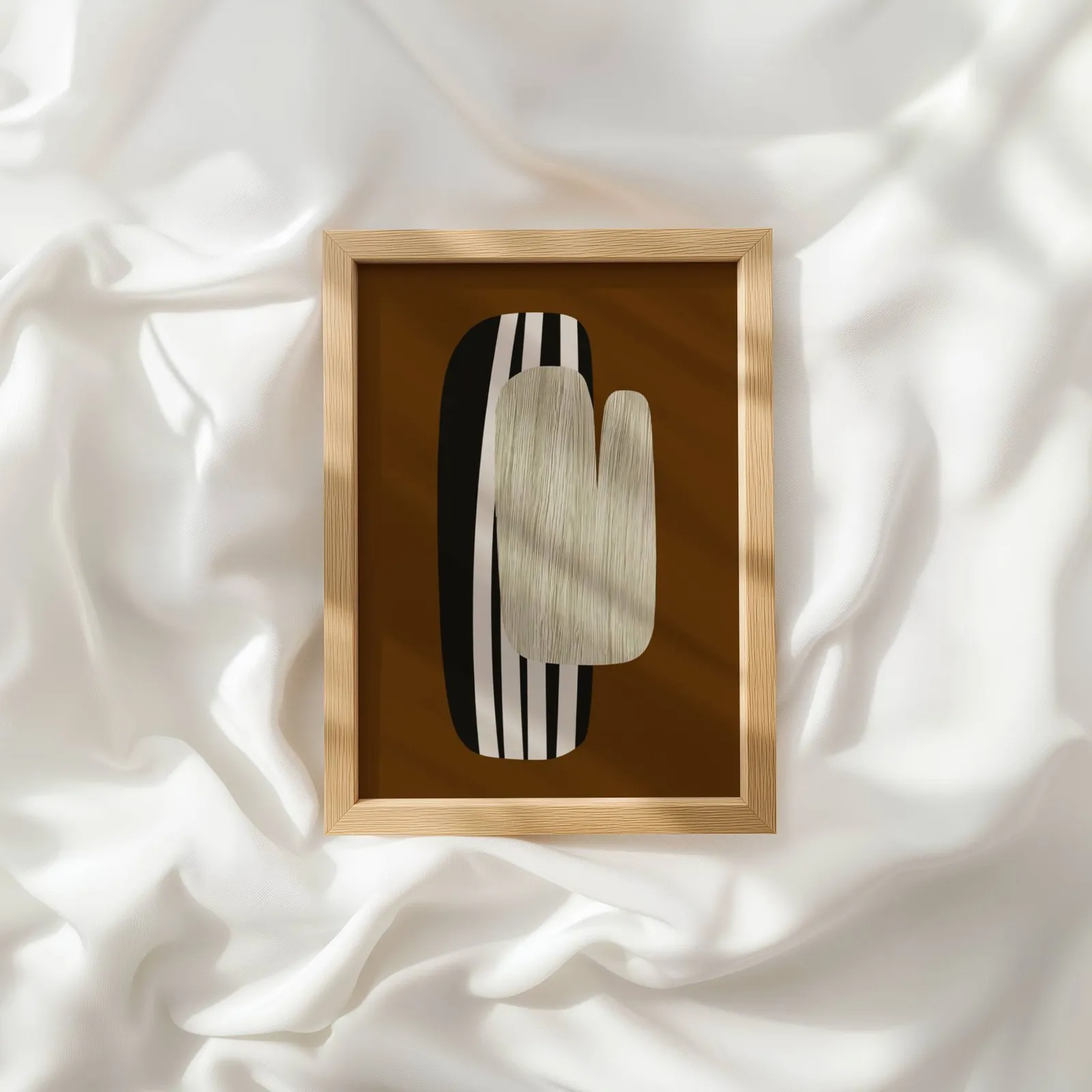 brown abstract wall art, resting atop rumpled white silky fabric