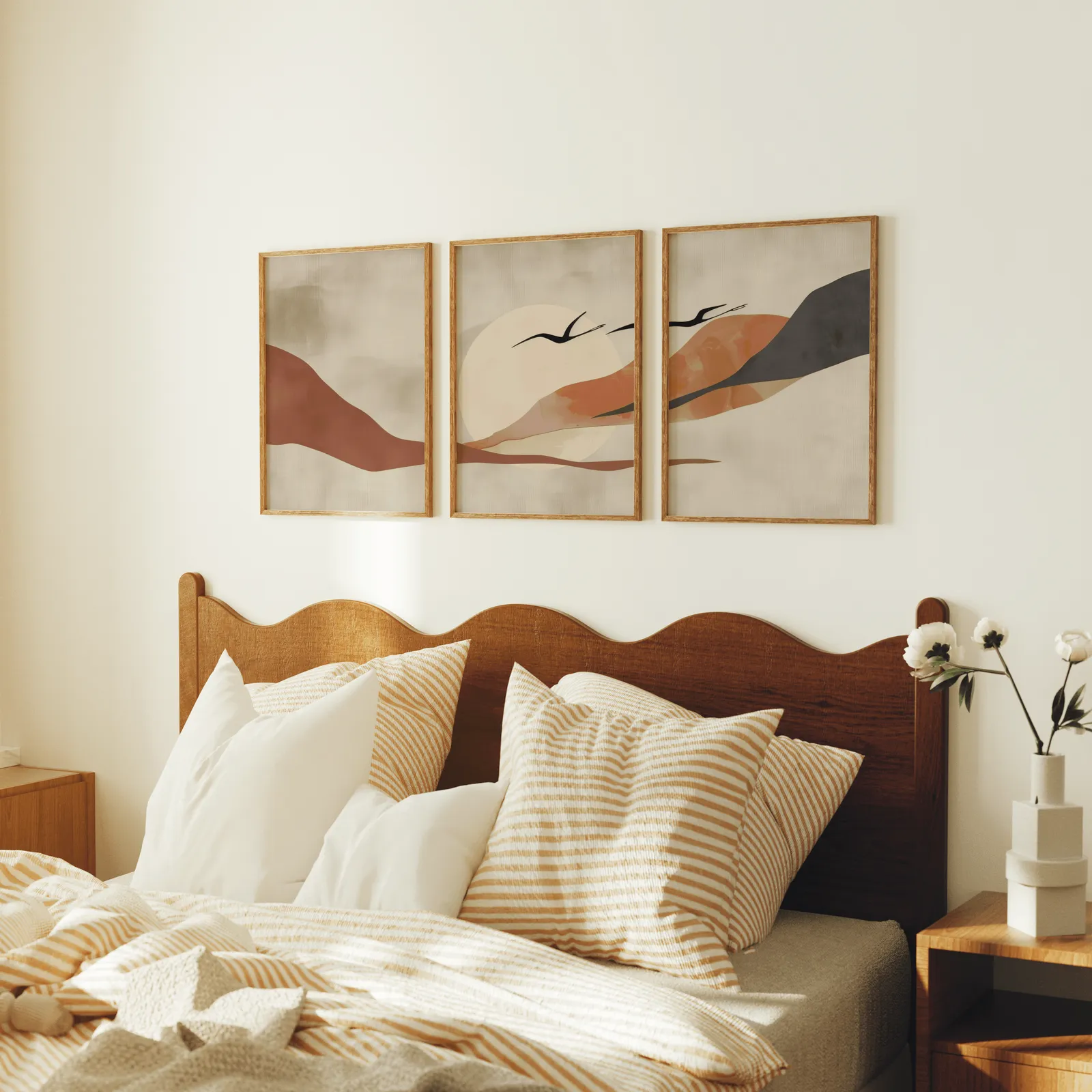 terracotta landscape wall art set of 3 with birds, above a scalloped wooden headboard with striped pillows