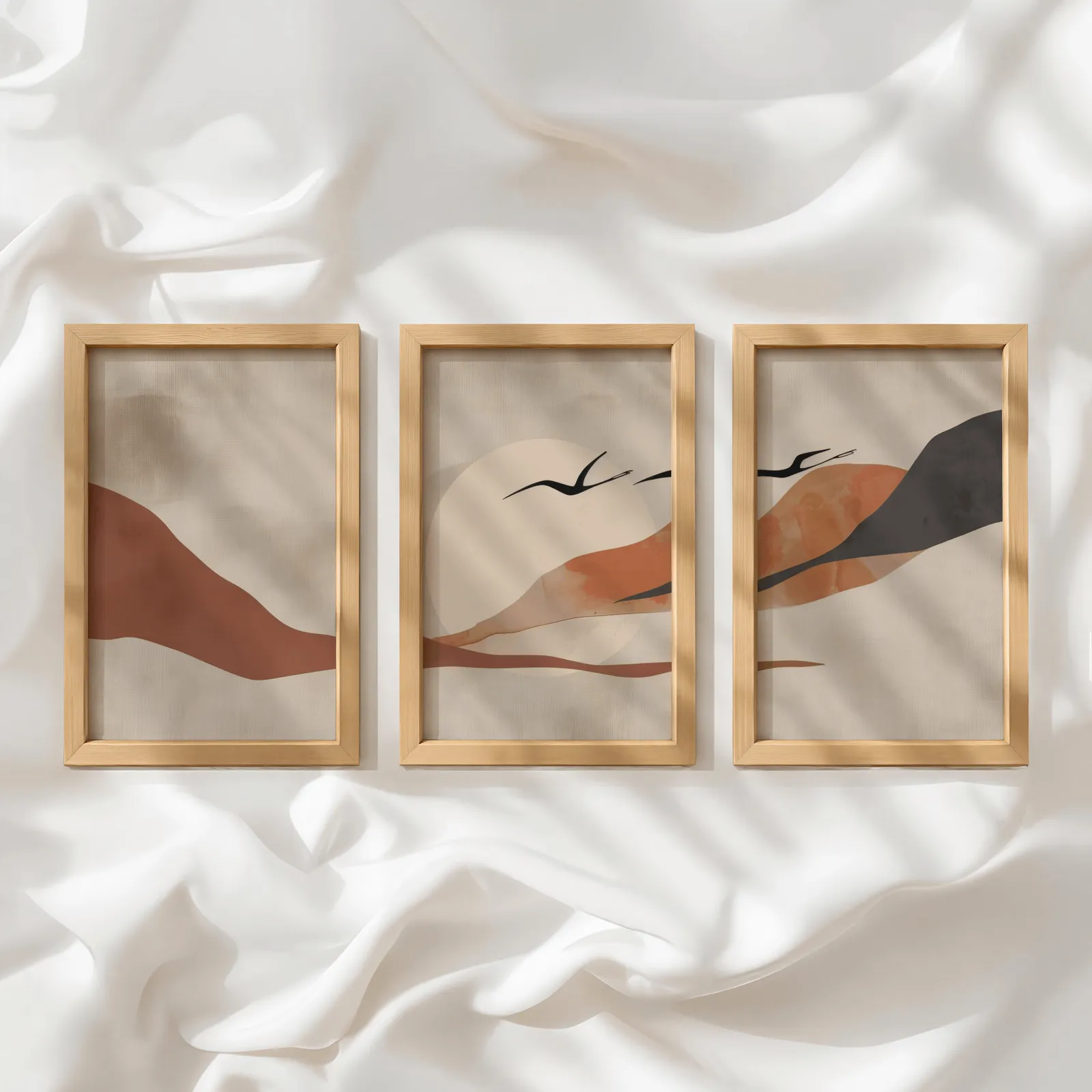 terracotta landscape wall art set of 3 with birds, in a row atop rumpled white silky fabric