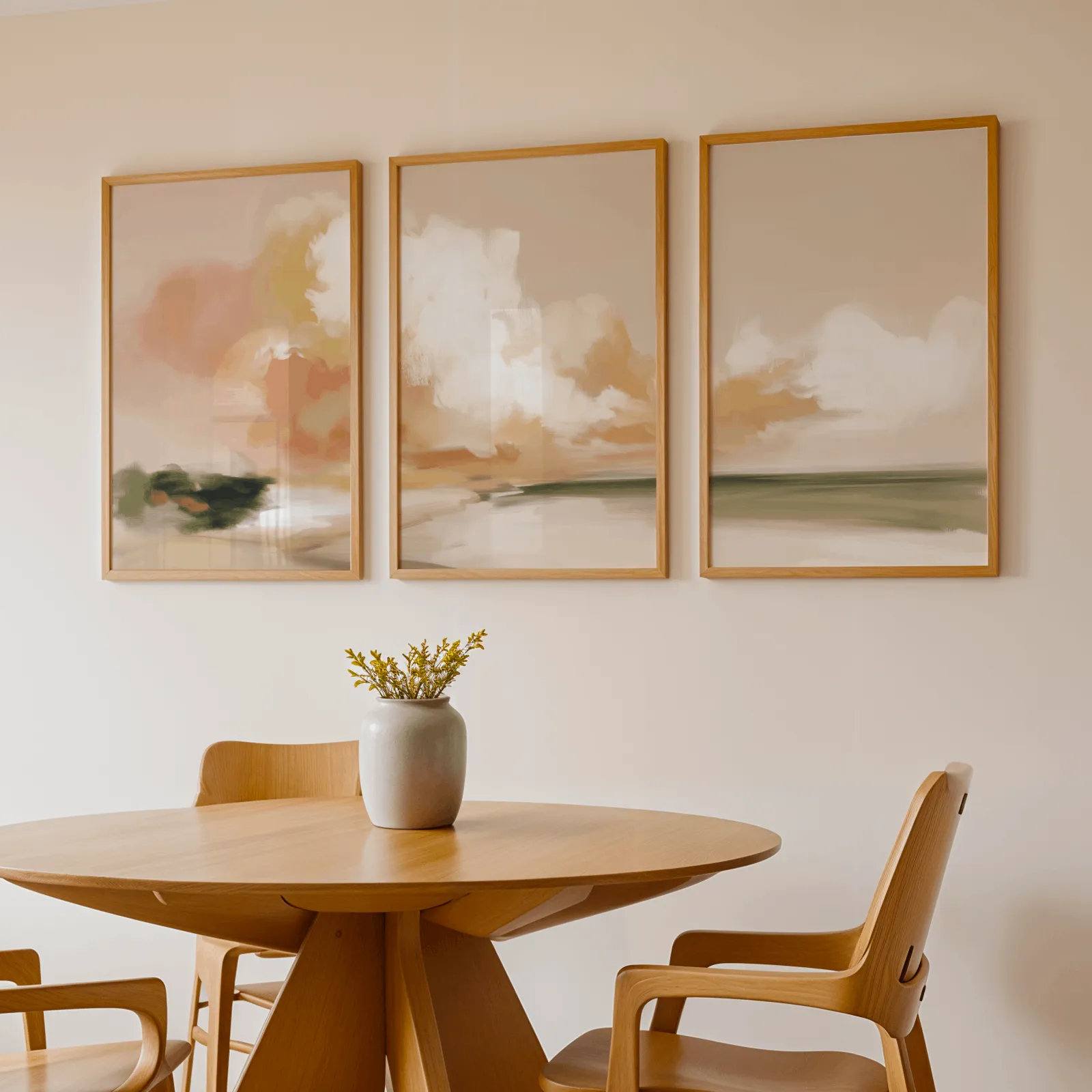 terracotta coastal landscape triptych wall art, above a round wooden table with a stoneware vase