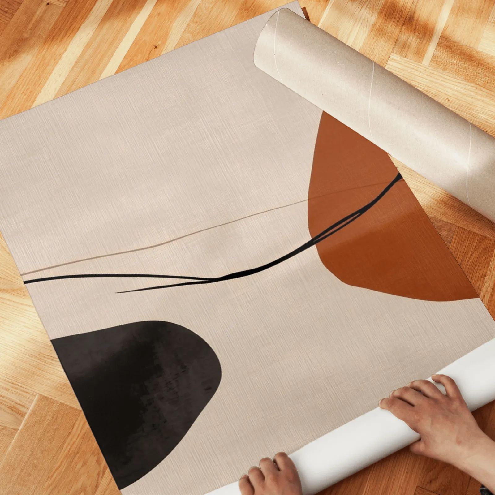 terracotta abstract set of 3 wall art, unrolled across a herringbone wood floor by hand