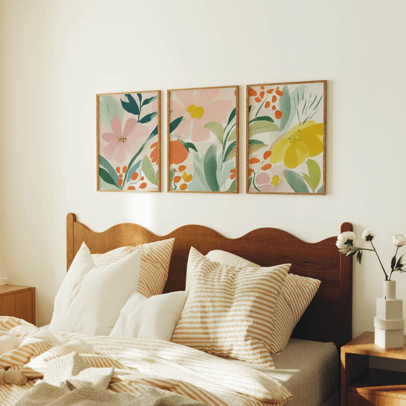 colorful floral botanical wall art set of 3, above a scalloped wooden headboard with striped pillows