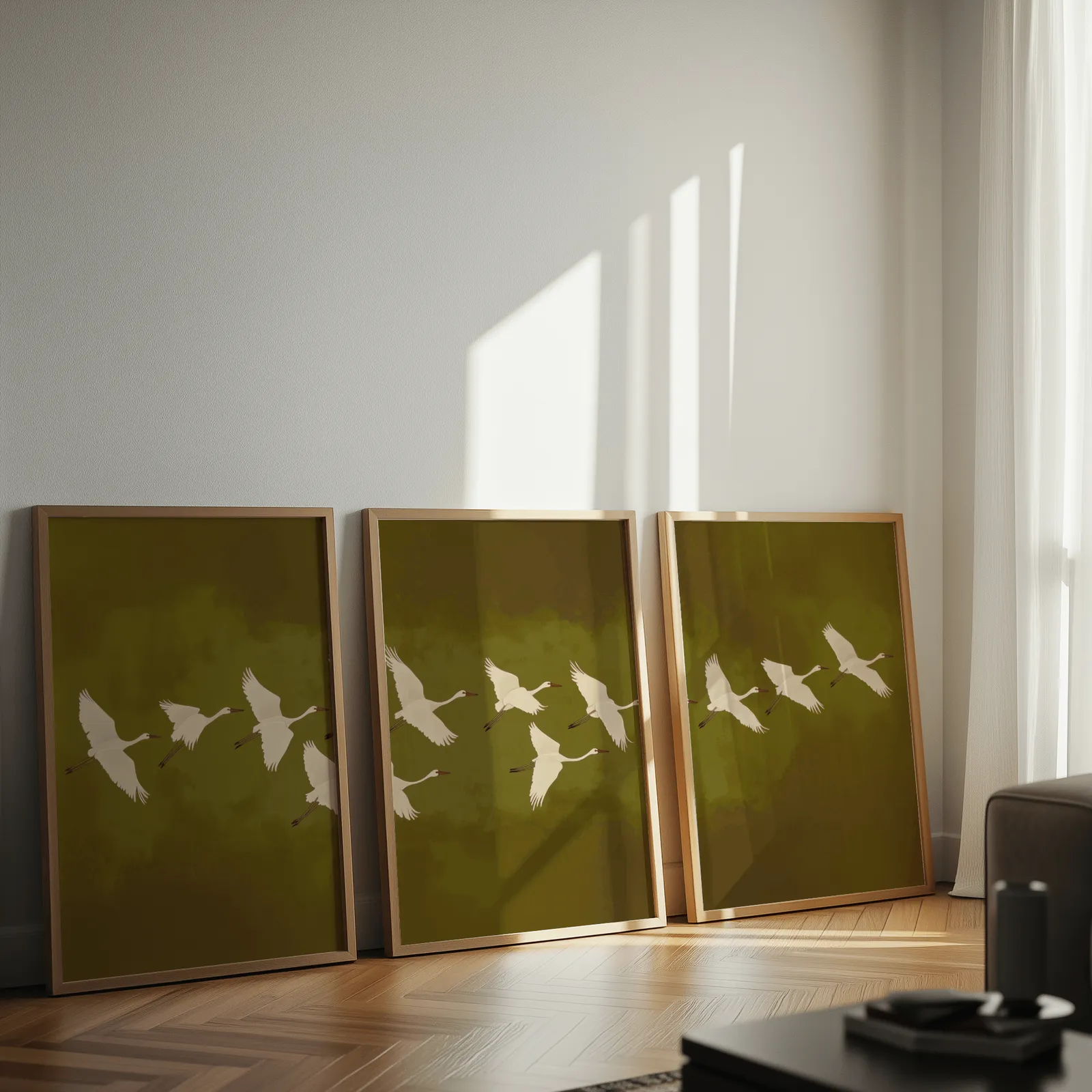 green cranes triptych wall art, leaning against a sunlit wall on herringbone flooring