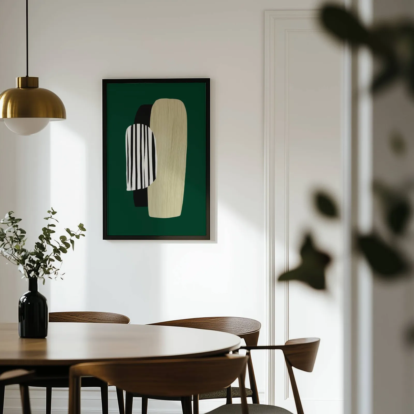 green abstract minimalist wall art with totem shapes, on a white wall above a round wooden dining table