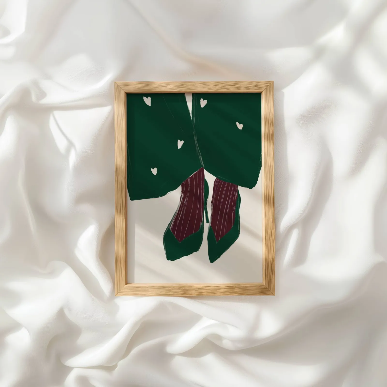 green heart pattern coat with burgundy heels wall art, resting atop rumpled white silky fabric
