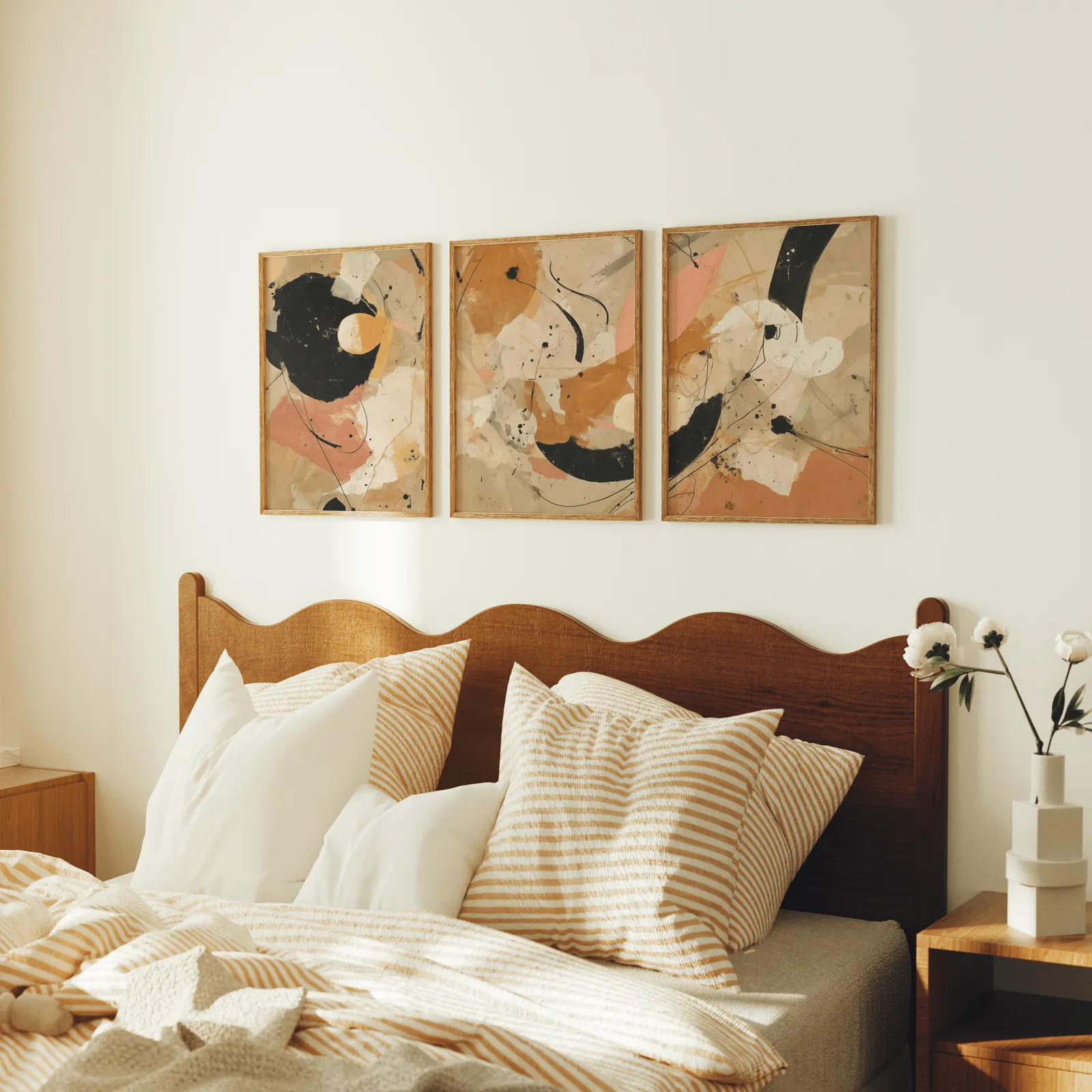 terracotta black abstract three piece wall art, above a scalloped wooden headboard with striped pillows