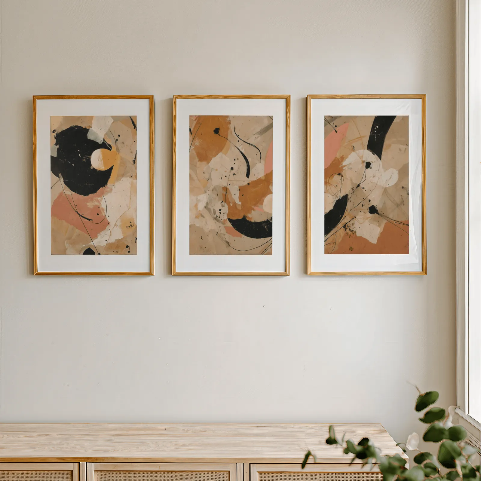 terracotta black abstract three piece wall art, in a row above a light wooden sideboard near a window