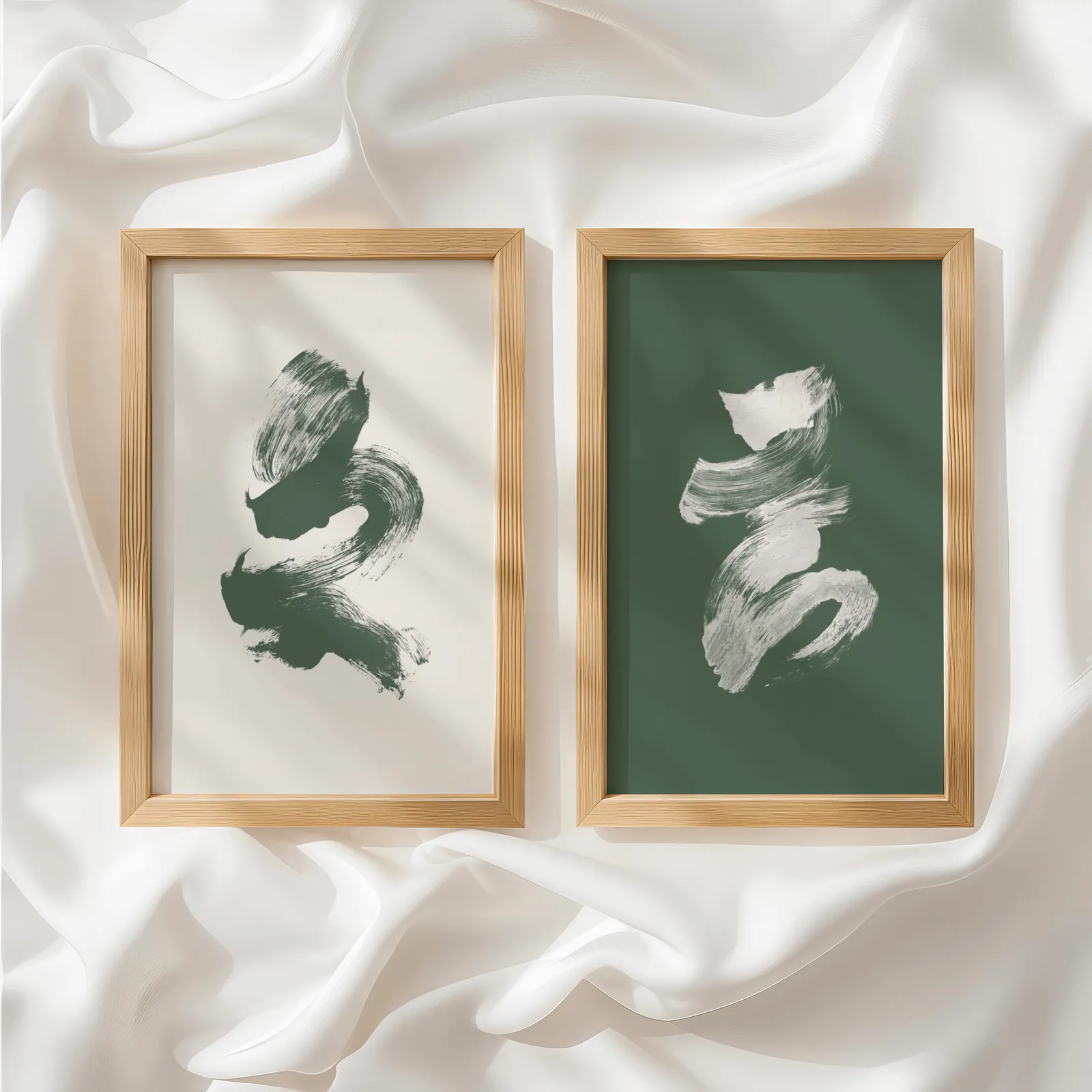 green and cream abstract brushstroke wall art set of 2, side by side atop rumpled white silky fabric