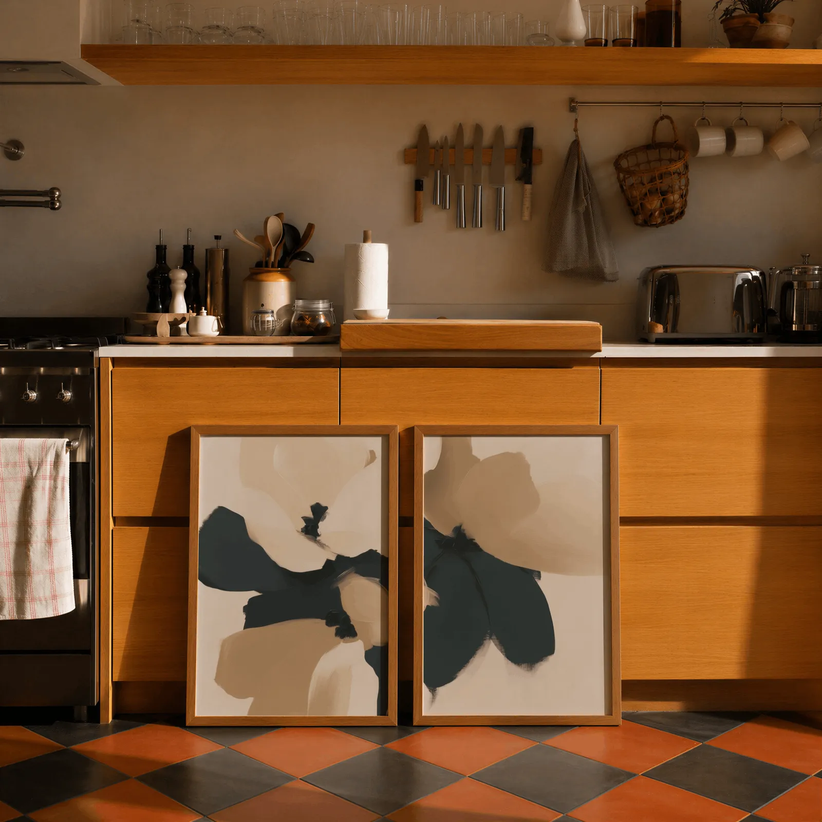 beige and black abstract floral wall art set of 2, leaning against wooden cabinets on terracotta tiled floor
