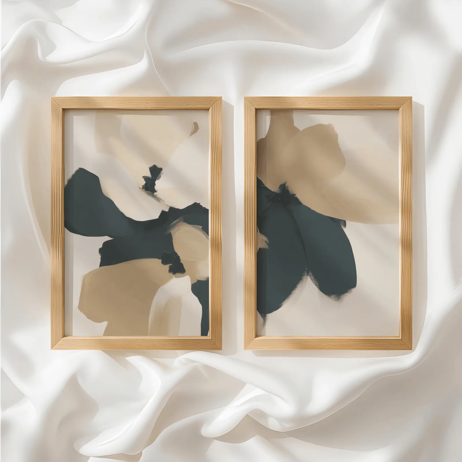 beige and black abstract floral wall art set of 2, side by side atop rumpled white silky fabric