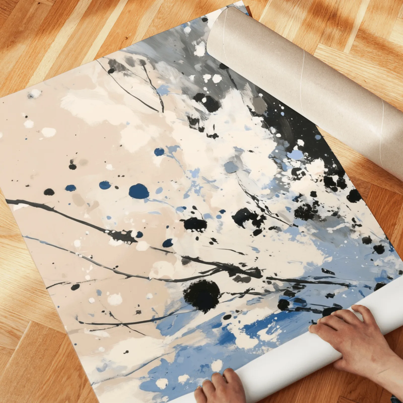 blue and beige abstract splatter triptych wall art, unrolled across a herringbone wood floor by hand