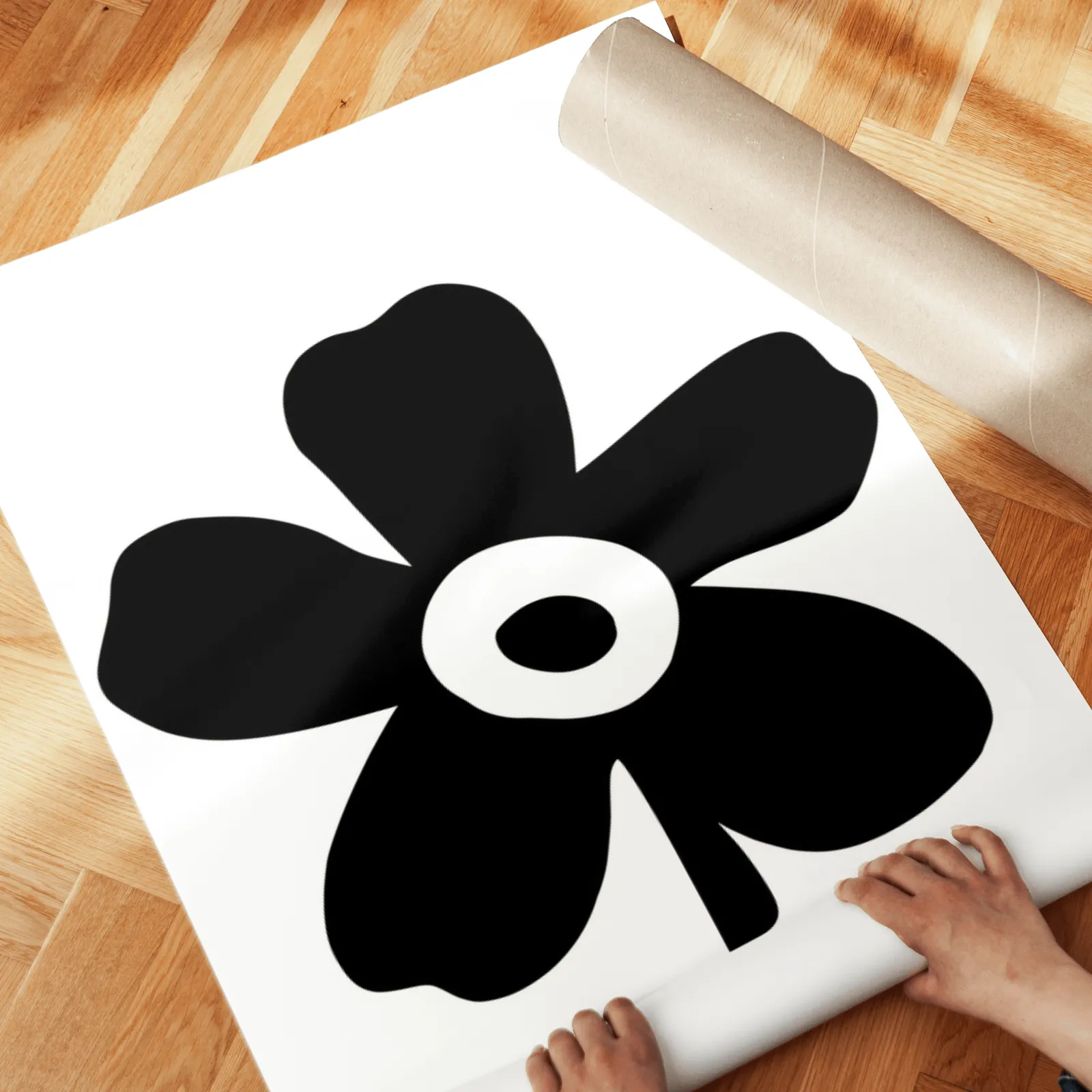 black and white floral wall art set of 2, unrolled across a herringbone parquet floor by hand